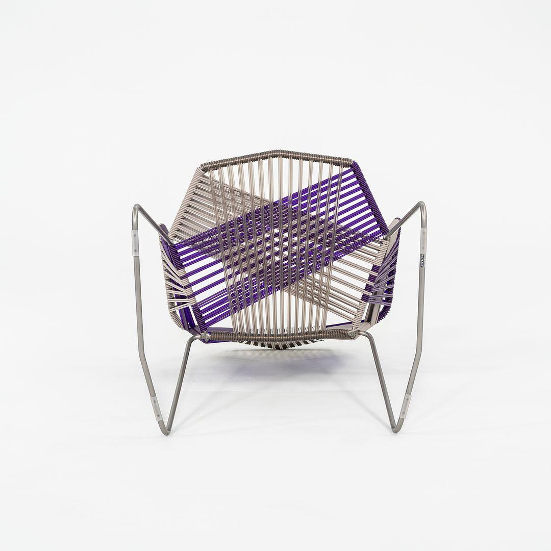 This is a Tropicalia chair with arms, originally designed by Patricia Urquiola in 2008. This particular example was produced by Moroso in Italy circa 2023. The chair is comprised of a tubular stainless steel base with a powder coated finish and