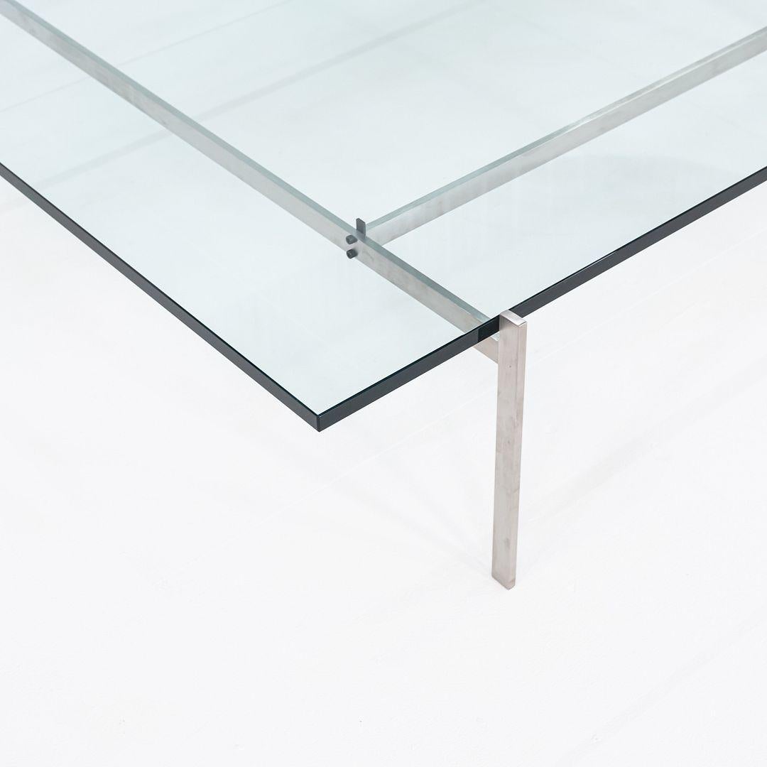 This is a PK61A Coffee Table, originally designed by Poul Kjaerholm for Frtiz Hansen in 1956. This particular example was produced in Denmark in 2023. The table is comprised of a stainless steel frame with a glass tabletop. 
 
 The table measures