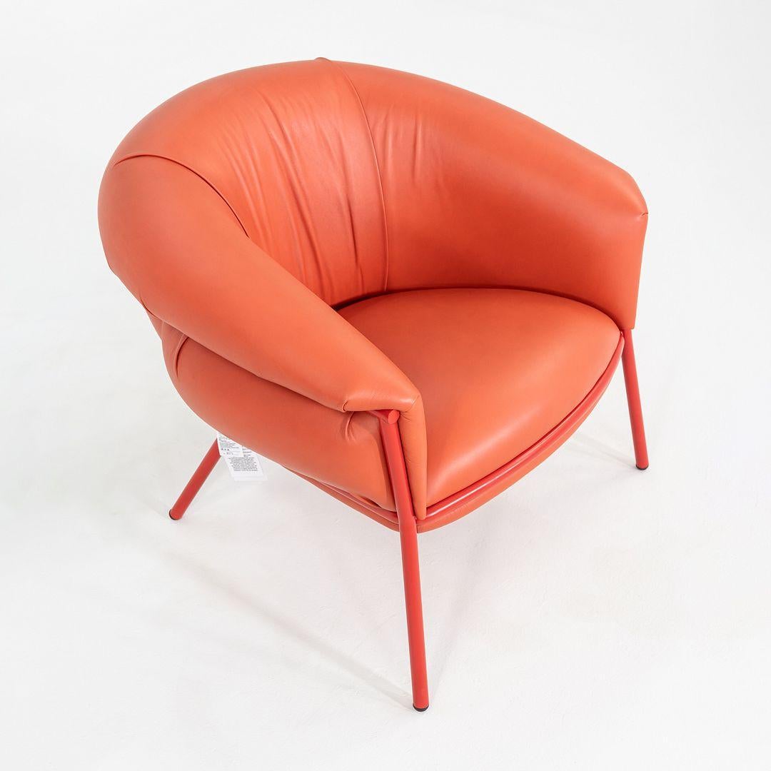 This is a Grasso Lounge Chair, originally designed by Stephen Burks in 2018. This particular example was produced by BD Barcelona in Spain in 2023. The chair is comprised of a powder coated tubular steel frame and is upholstered in an orange
