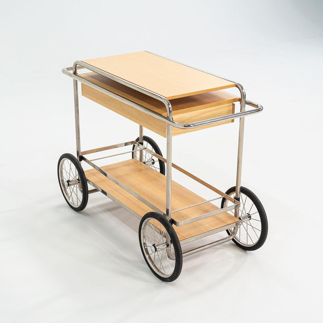 This is a M4RS bar trolley, originally designed and produced by Tecta in 2002. This particular example was made in Germany in 2023. The cart is comprised of tubular steel and wood with oak surfaces. 
 
 The bar trolley measures 50 inches long, 20
