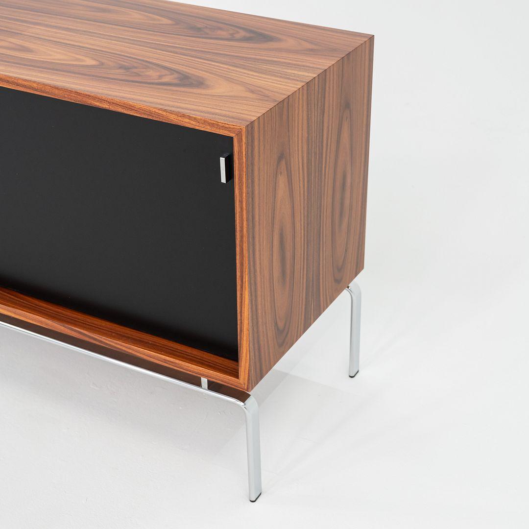 This is a FK150 Sideboard, originally designed by Jorgen Kastholm for Lange Production in 1973. This particular example was produced in Denmark in 2024. It has a case composed of palisander veneer atop a chrome-plated steel base and legs. 
 
 The