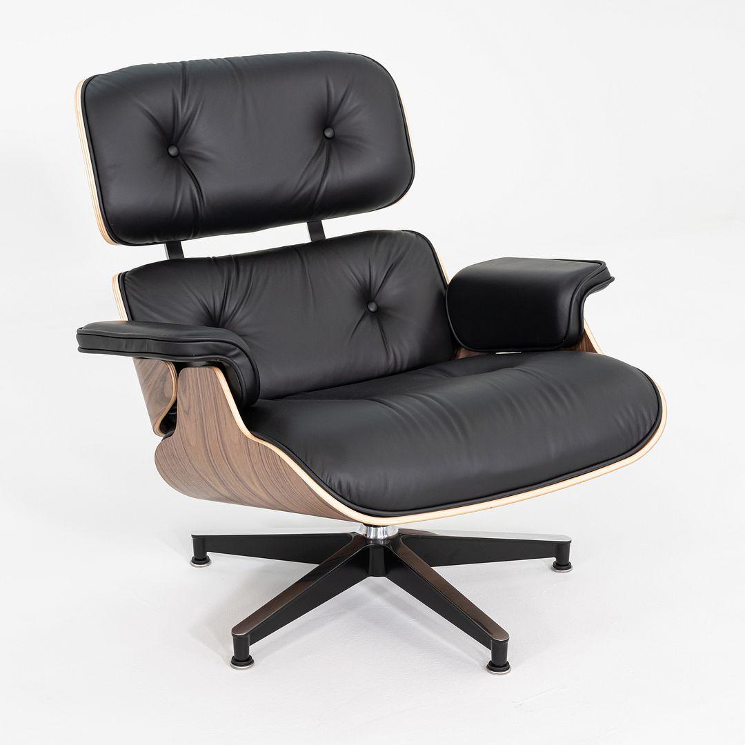 Il s'agit d'une chaise longue et d'un pouf Eames, modèles 670 et 671, conçus à l'origine par Charles et Ray Eames pour Herman Miller en 1956. Cette série a été produite aux États-Unis en 2025. Les coques de cet ensemble sont en noyer, le siège et