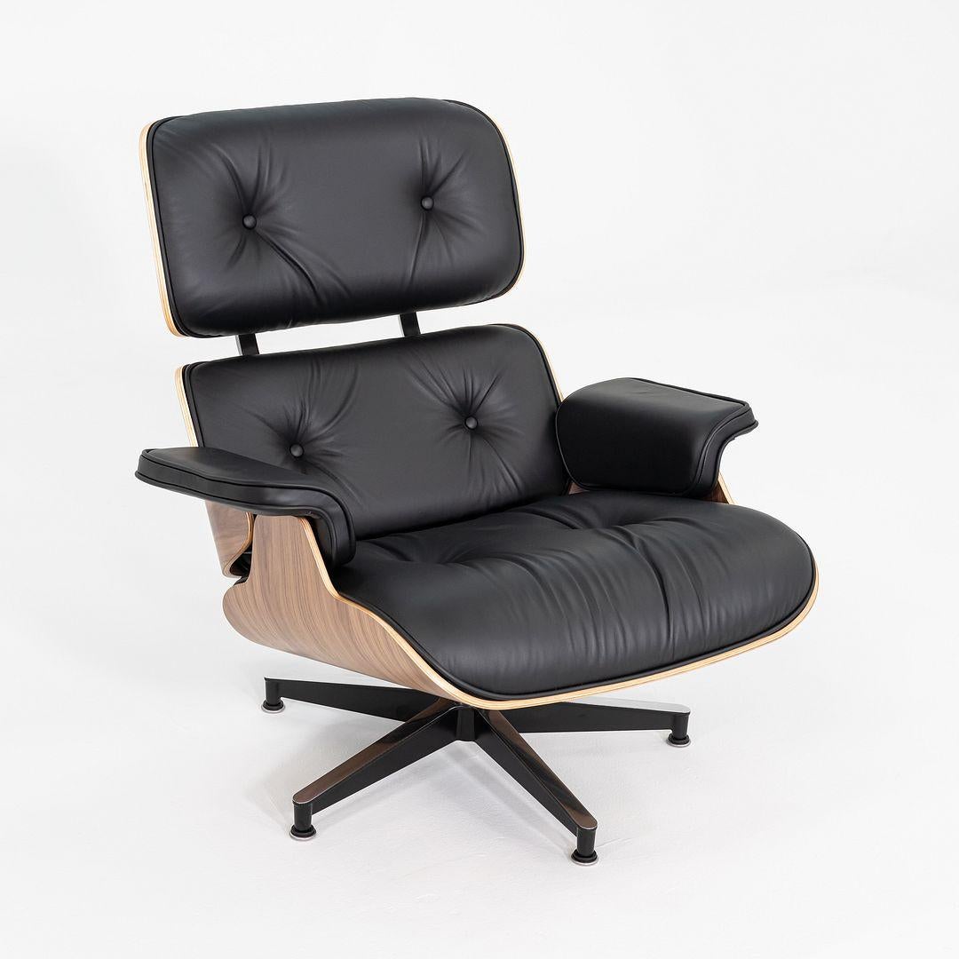Il s'agit d'une chaise longue et d'un pouf Eames, modèles 670 et 671, conçus à l'origine par Charles et Ray Eames pour Herman Miller en 1956. Cette série a été produite aux États-Unis en 2025. Les coques de cet ensemble sont en noyer, le siège et