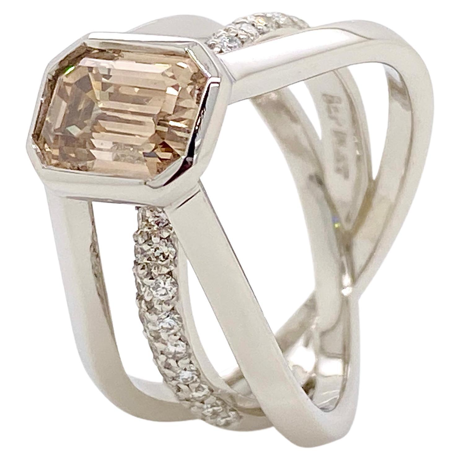 Champagne for two.
When designing and making special Creations we often take inspiration from the centrepiece gem itself to decide on the design. Typically the emerald cut has clean crisp, open lines and the simplicity of the cut is matched by no