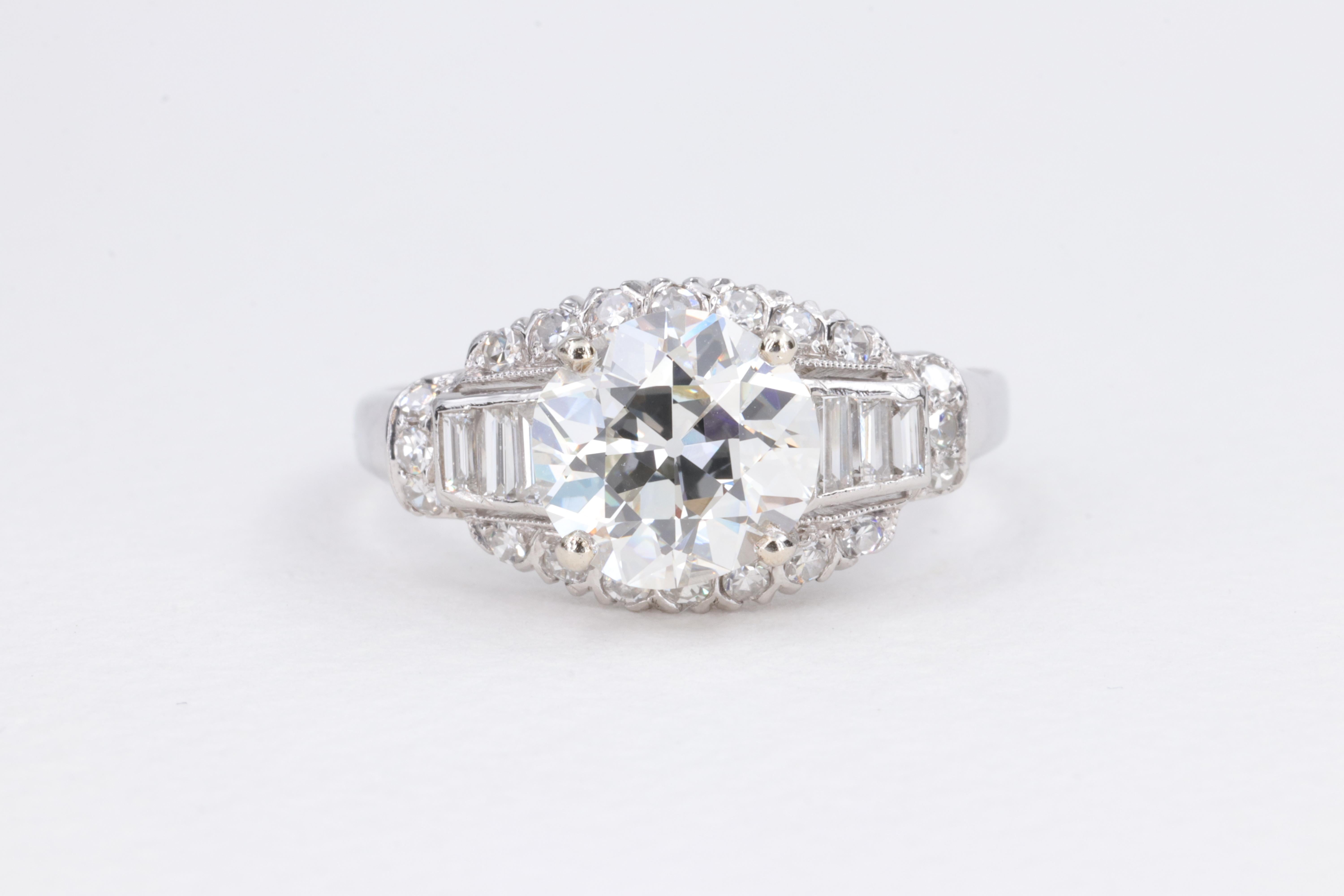 Bague de fiançailles en platine et diamant datant du début du milieu du siècle, comprenant un diamant de 2,02 carats de couleur I et de pureté VS1, de taille européenne ancienne, classé par le GIA, serti d'environ 0,25 carat de diamants baguettes et