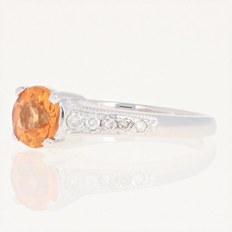 Sweet, luscious color awaits with this sparkling treasure! This 14k white gold ring features a lively Mandarin garnet solitaire accompanied by radiant diamond accents set along the milgrain-outlined shoulders.  

This ring is a size 8 1/4, but it