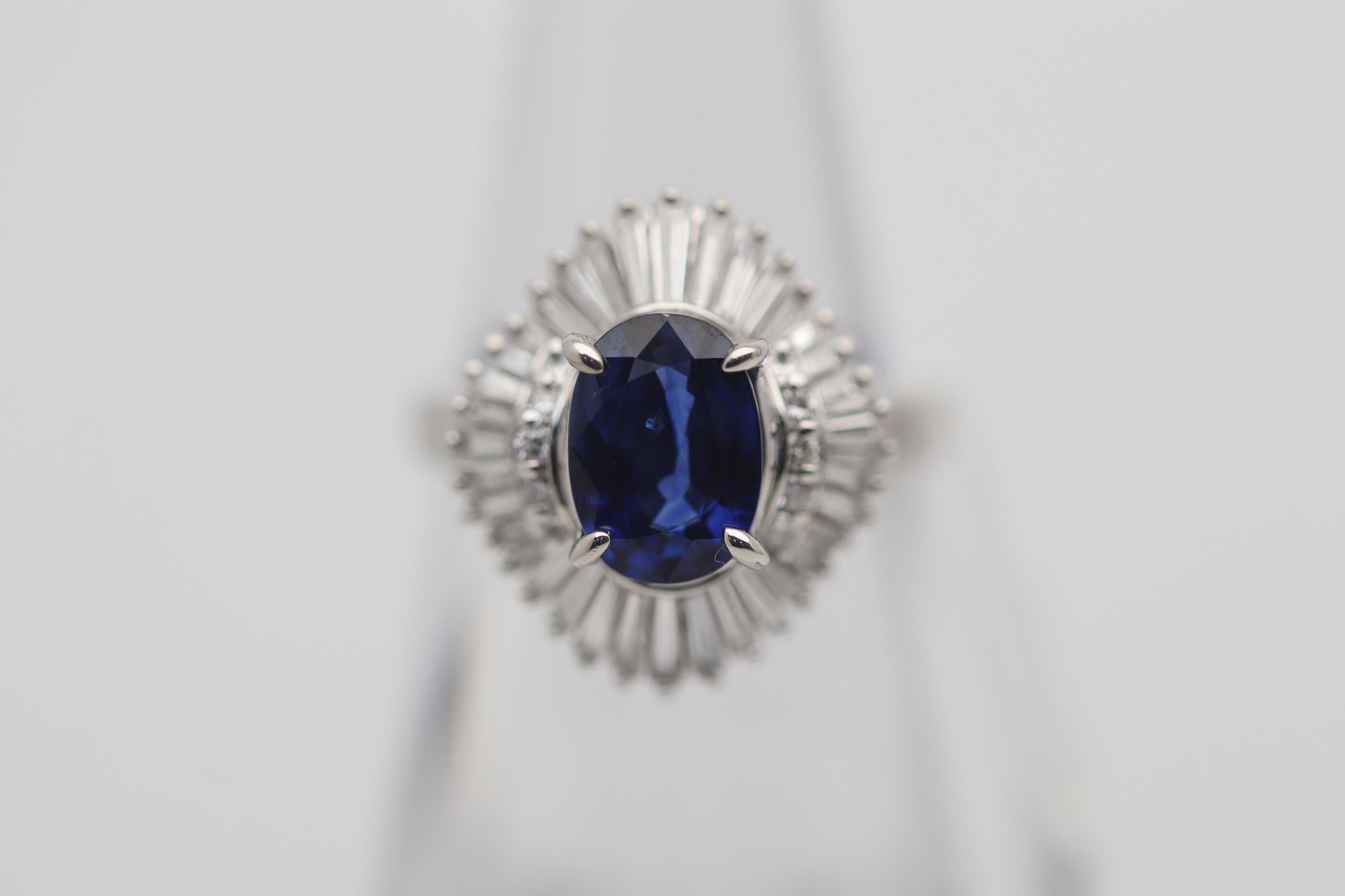 A sweet and stylish ring featuring a 2.03 carat oval-shape sapphire with a fine rich blue color and great brightness. It is surrounded by 1.05 carats of round brilliant and baguette-cut diamonds set in a ballerina style around the gem.