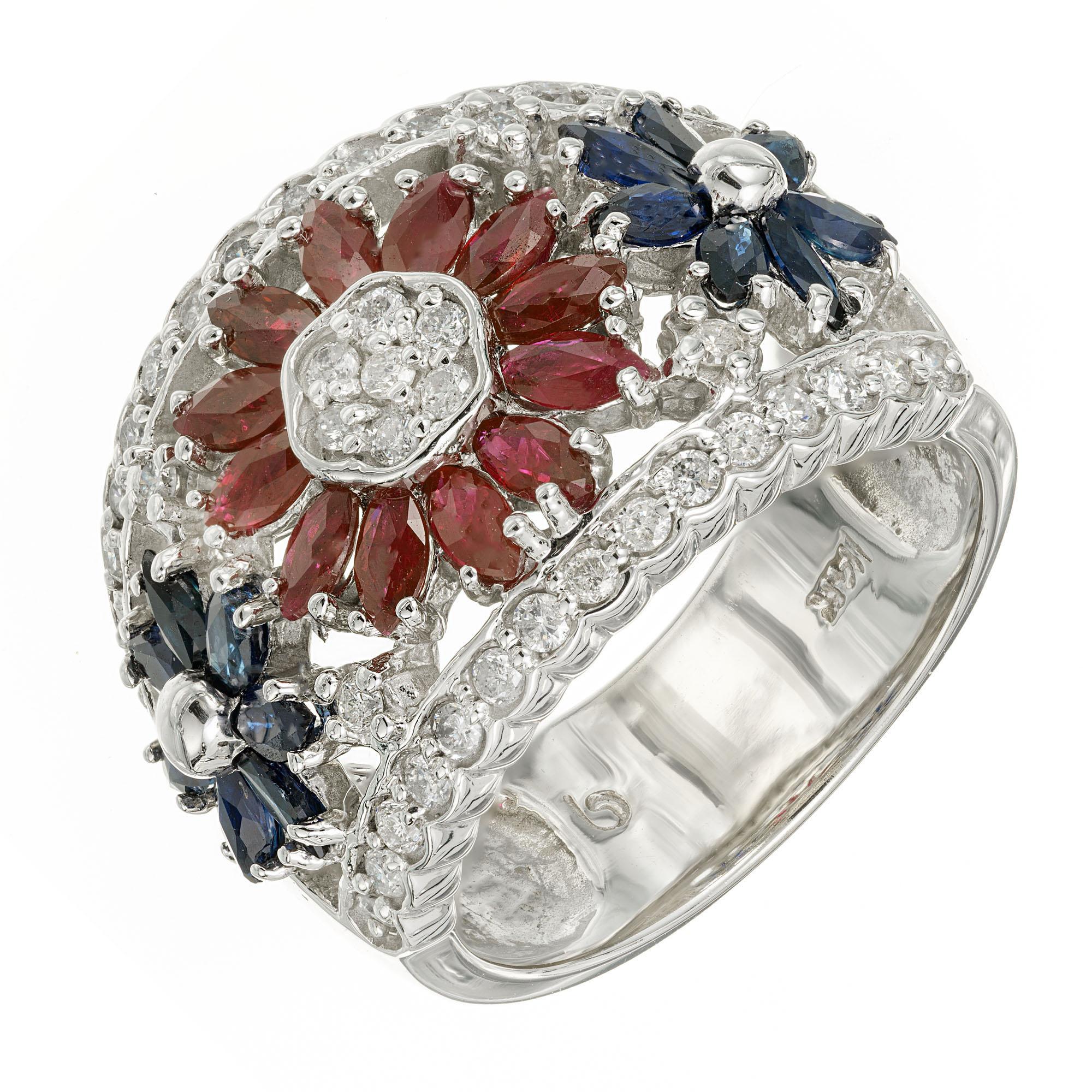 Wide tapered open work flower ring, set with 14 marquise sapphires and 12 marguise rubies with 41 round accent diamonds, set in 14k white gold wide band setting. 

14 marquise blue sapphires, approx. .84cts
12 marquise red rubies, approx. .72cts
41