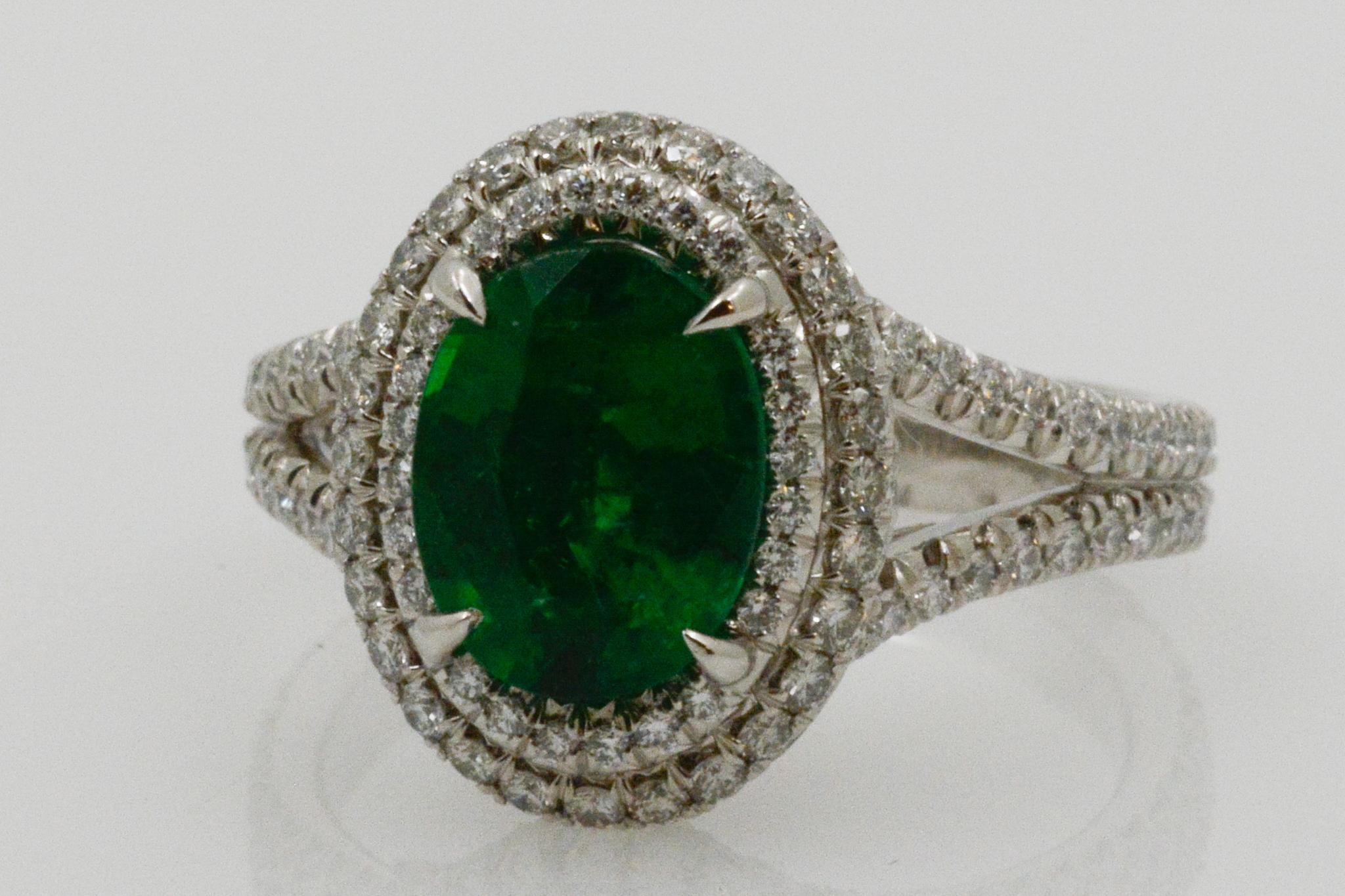 From Eiseman Jewels, this platinum ring features a center oval emerald weighing at 2.03 carats. The emerald is surrounded by a double pave halo of diamonds, weighing .89ctw. Size 6. 