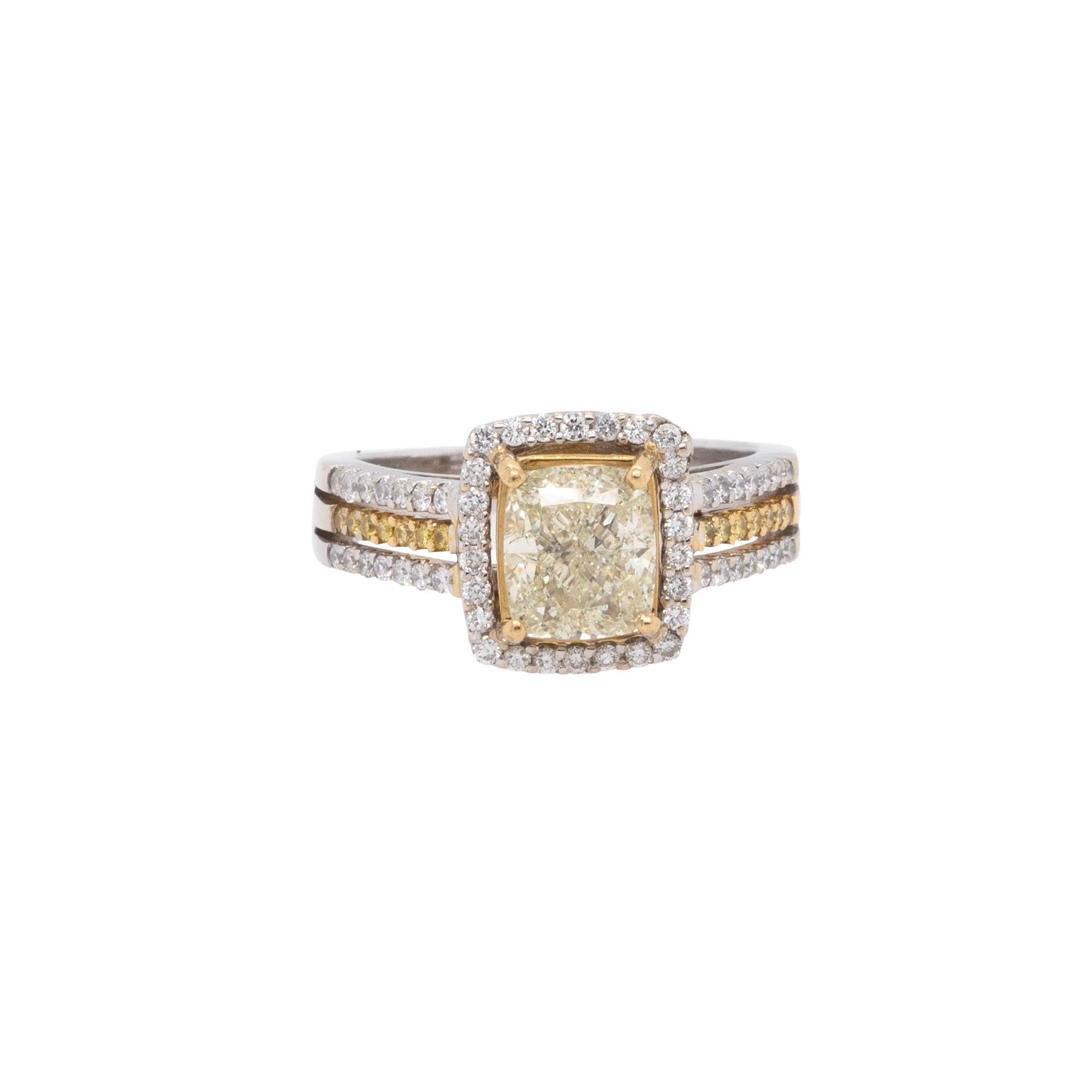 This is a fancy yellow diamond ring made of 14k white and yellow gold, with a total weight of 6.5g. It features a 2.03ct natural cushion cut diamond, surrounded by 1.00ctw of round cut natural diamonds. The ring measures 21mm x 11mm x 25.5mm and