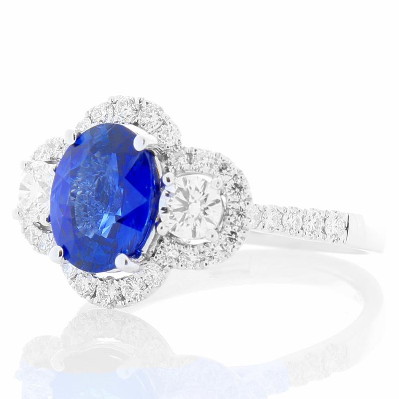 This sapphire and diamond ring has an art deco charm and timeless vintage-inspired elements that will be enjoyed for a lifetime. A vivid 2.03 carat, royal blue, oval sapphire radiates from the center of this ring. This gem is from Sri Lanka. It is