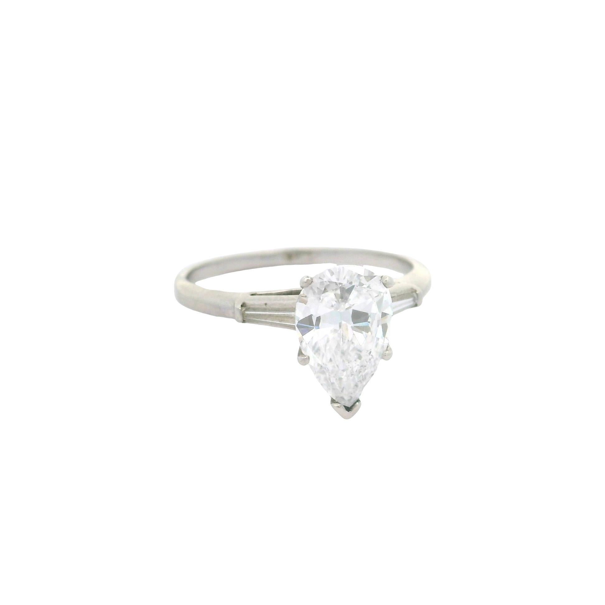 Un anello di fidanzamento di grande effetto con un diamante a forma di pera di 2,03 carati. È certificato da GIA come naturale e con un grado di colore D, il migliore possibile. L'anello è completato da due diamanti taglio baguette, in una classica