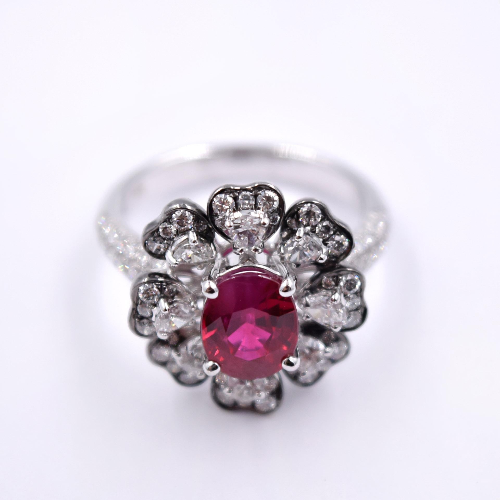 Beautiful flower shaped cocktail ring with white diamonds and a ruby center stone. 
The ruby has a weight of 2.03 carats and is set in a palladium and 18 karat white gold prong setting.
1.08 carats of white diamonds are carefully set around the