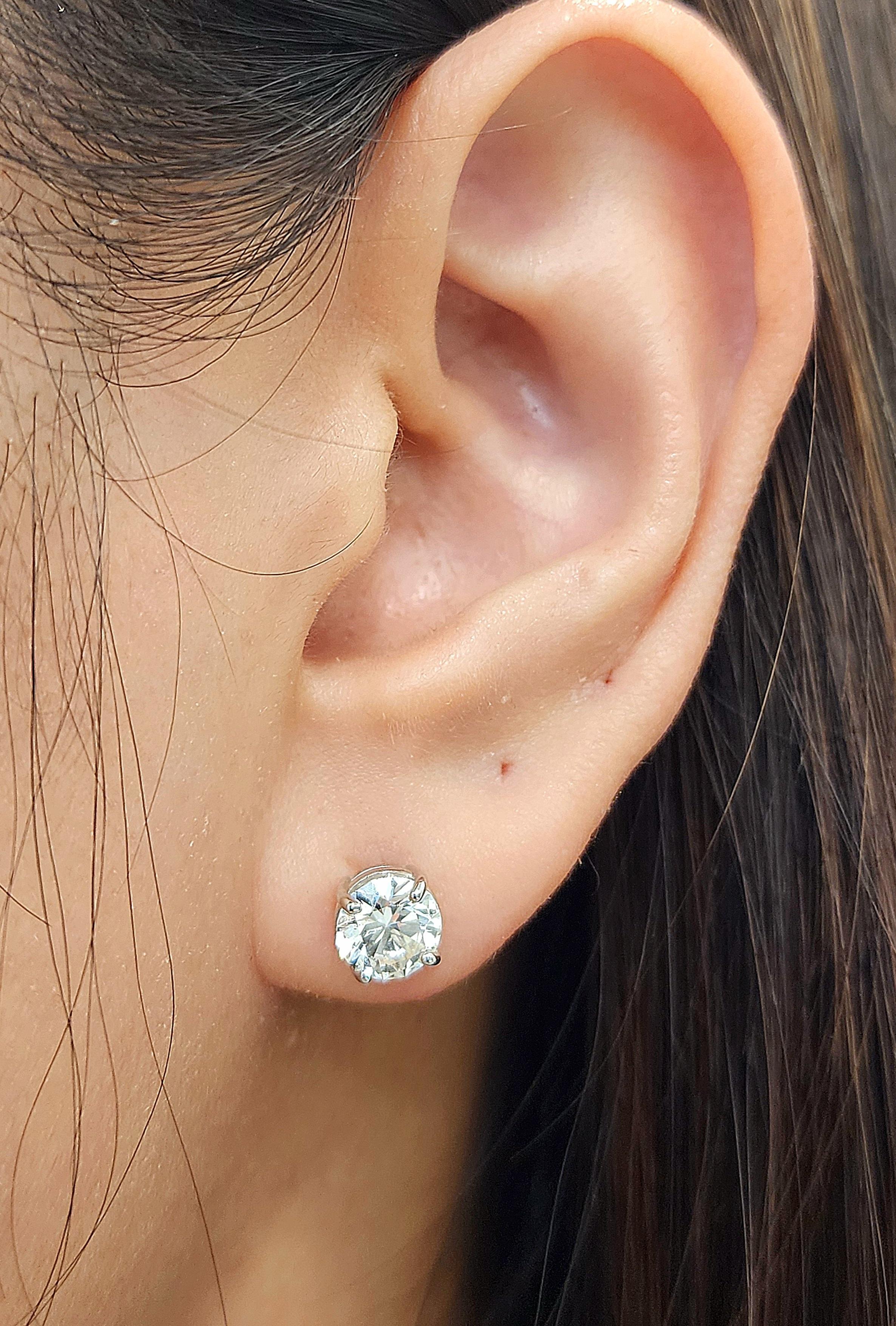 These elegant stud earrings feature 2.03 carats of round-cut diamonds set in 14 karat white gold. The diamonds are G/H in color and SI1/SI2 in clarity, which makes them a refined choice for any occasion. Their classic design ensures that they will