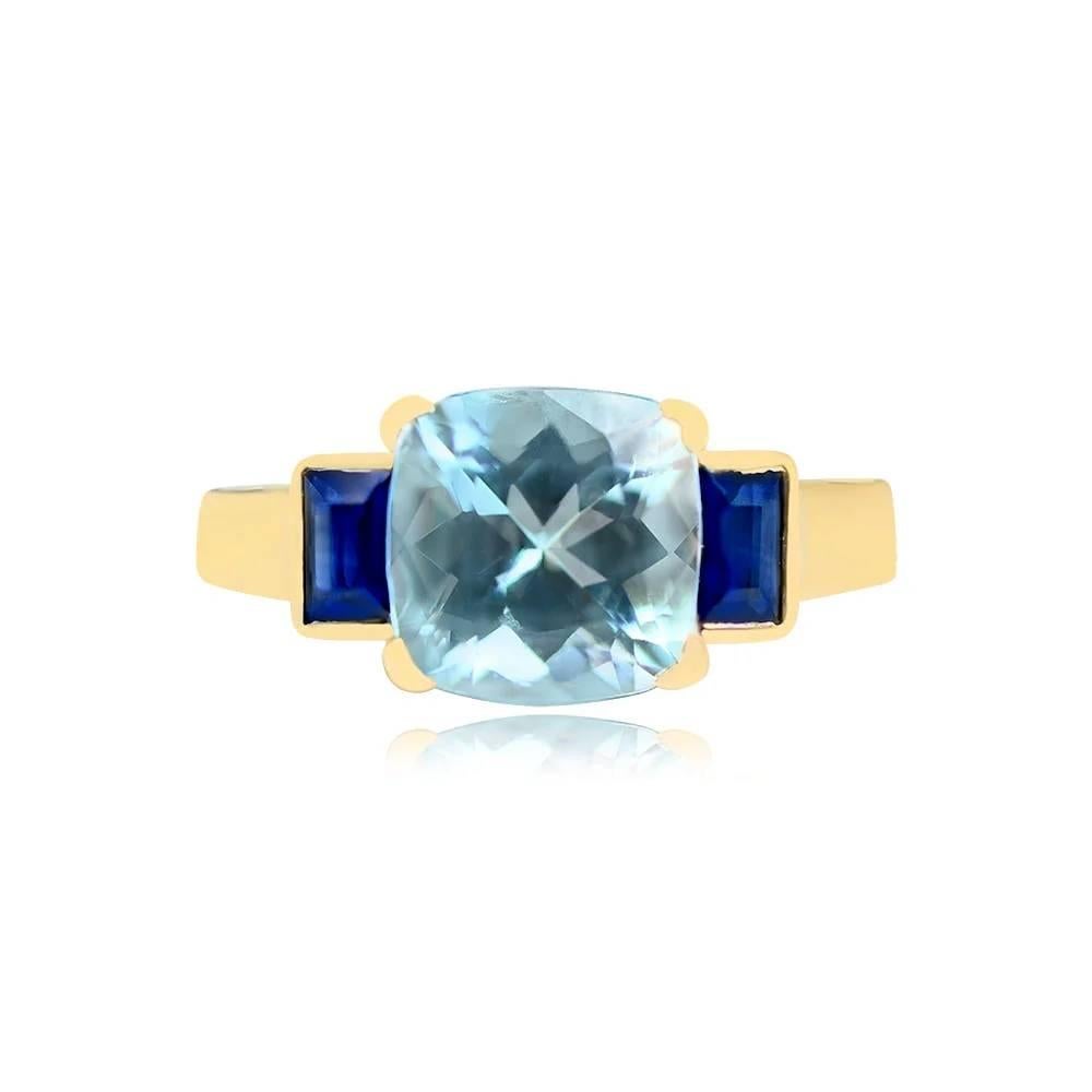 A captivating gemstone ring showcasing a vibrant cushion-cut aquamarine weighing approximately 2.03 carats, boasting strong saturation. Enhancing the center stone's allure are two natural blue baguette-cut sapphires, skillfully set in bezels. The