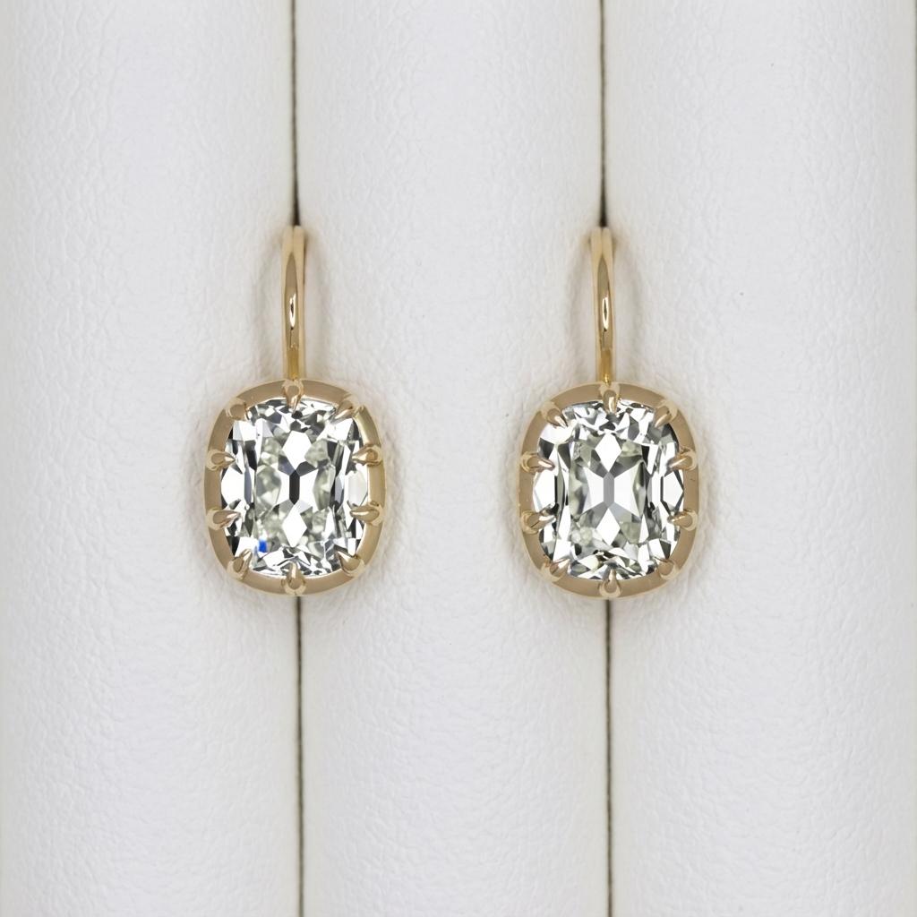 Ces élégantes boucles d'oreilles pendantes mettent en valeur une paire de diamants naturels taille ancienne de 2,04 carats, chacun certifié par le GIA et monté sur de l'or jaune 14k raffiné. Les pierres sont des reproductions d'anciennes tailles de
