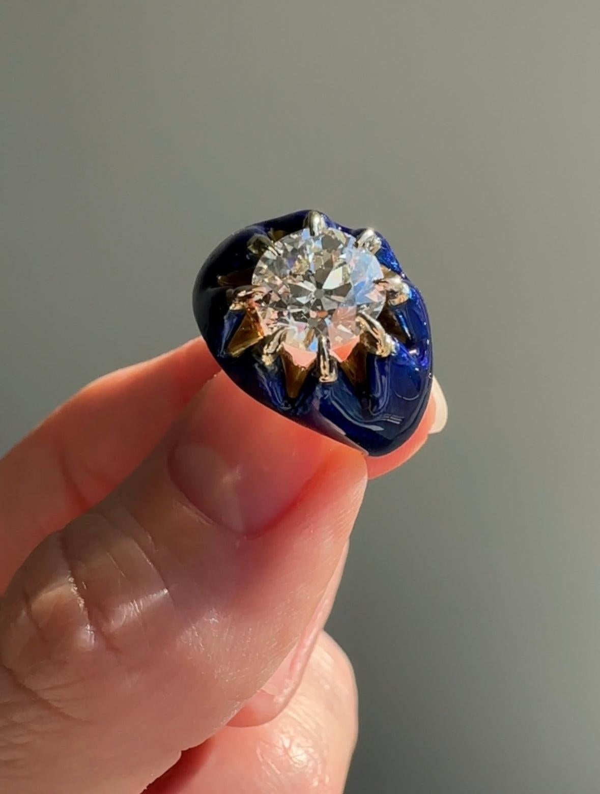 This striking and distinctive vintage ring boasts a gorgeous 2.04 carat old mine cut diamond, sparkling from within a buttercup setting adorned with with an incredible, bright cobalt blue guilloche enamel. Rendered in 18k gold, this ring is a