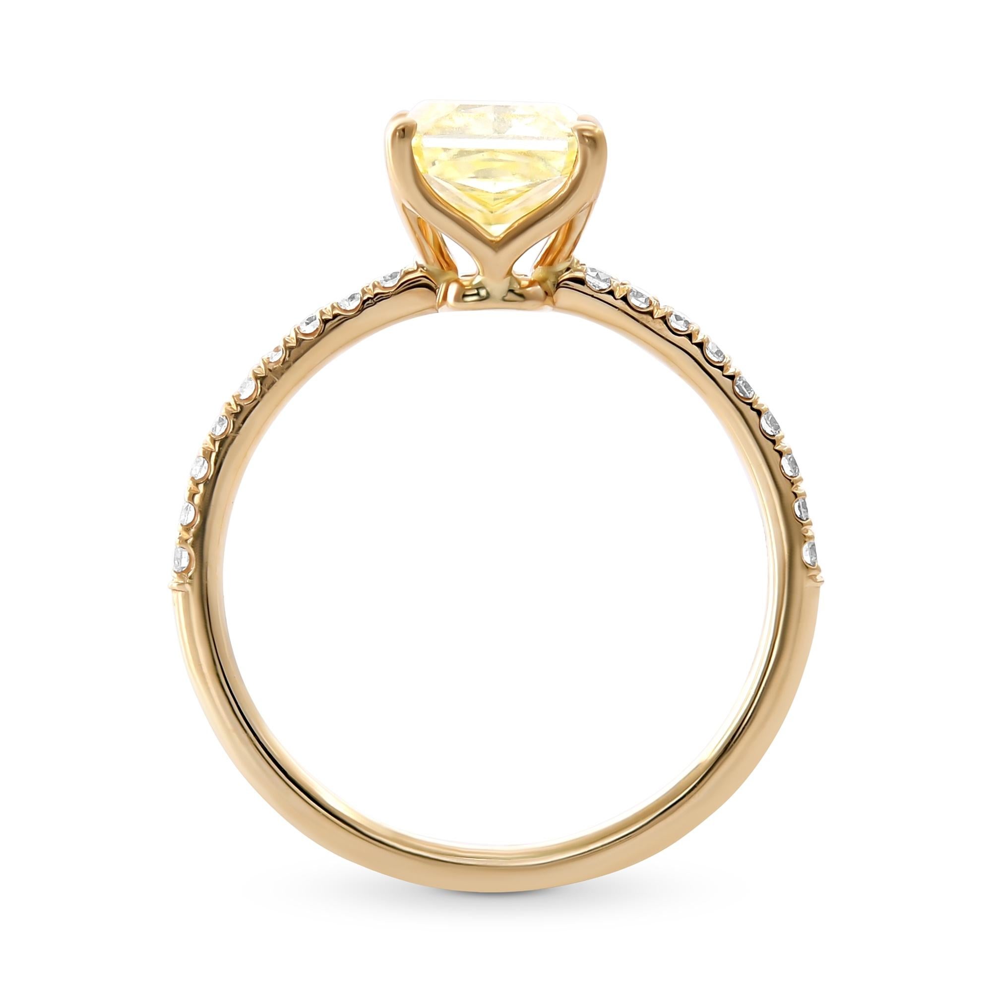 Este anillo de oro amarillo de 18 quilates exhibe un diamante Fancy Yellow Radiant certificado por el GIA con claridad VVS1, realzado por elegantes piedras laterales para un aspecto refinado y brillante.