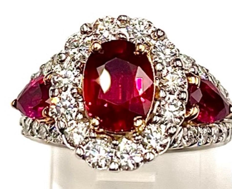 This is an absolutely stunning ring. It features a Natural 2.04Ct Oval Burmese Ruby flanked by 2 Natural Pear Shape Burmese Rubies of 1.00Ct Total Weight and 38 Natural White Round Brilliant Diamonds of 1.02Ct Total Weight. High quality Burmese