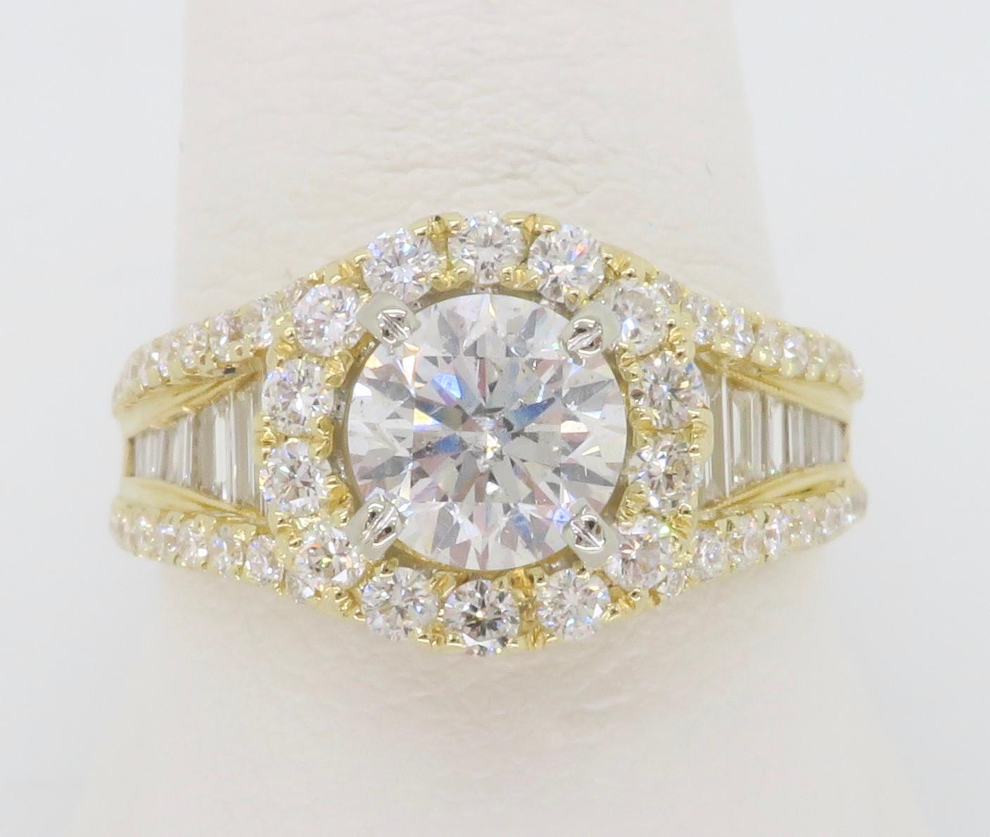 Stunning Diamond engagement ring featuring a Round Brilliant cut center stone flanked by a halo and baguette cut diamonds. 

Center Diamond Carat Weight: 1.04CT
Center Diamond Cut: Round Brilliant
Center Diamond Color: F
Center Diamond Clarity: