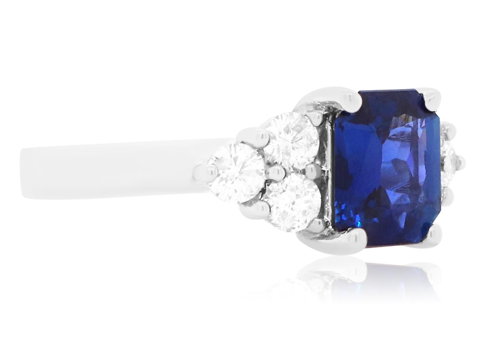 Material: 18k White Gold 
Center Stone Details:  1 Radiant Cut Blue Sapphire at 2.05 Carats - Measuring 8 x 6.8 mm
Diamond Details: 6 Brilliant Round White Diamonds at Approximately 0.70 Carats - Clarity: SI / Color: H-I
Alberto offers complimentary