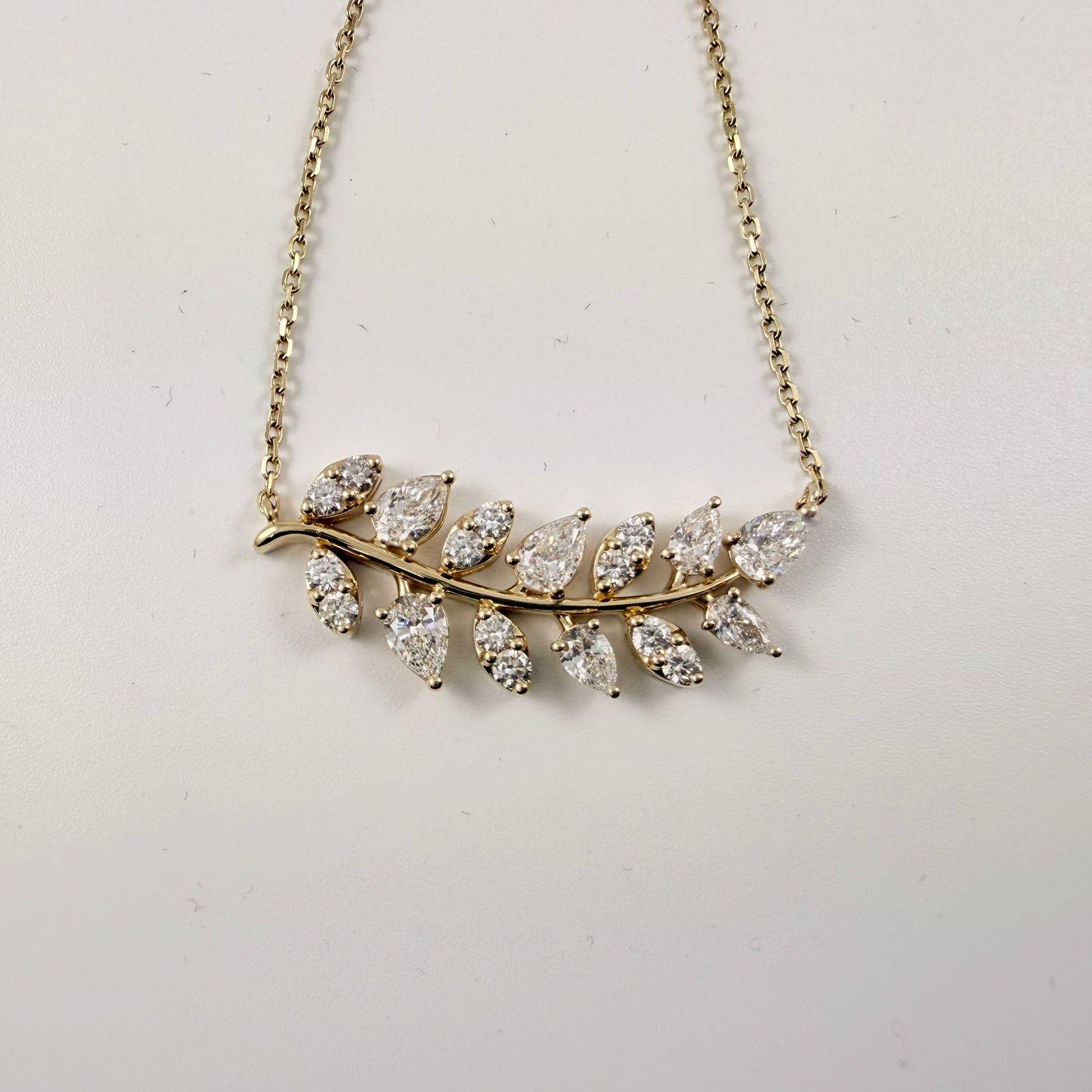Cet �époustouflant collier de feuilles de diamants en or jaune 14 carats est une célébration de l'élégance naturelle et de l'artisanat raffiné. Conçu avec un gracieux motif de feuilles, le pendentif présente un mélange harmonieux de diamants en forme