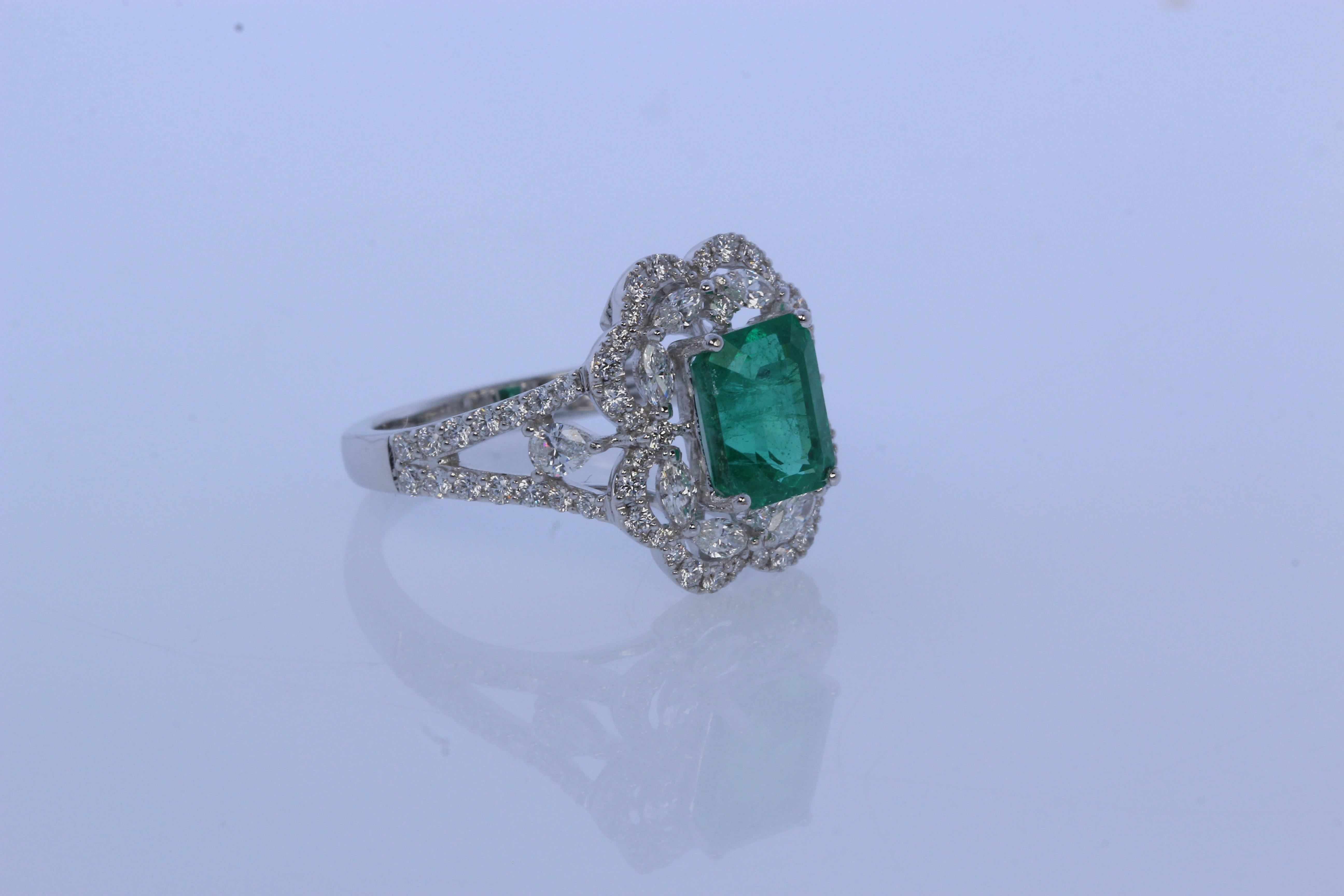 A brand new emerald and diamond ring in 18K gold. A 2.05 carat emerald cushion is set in the center of this ring, which is surrounded by 0.35 carat diamond marquise, 0.52 carat diamond round and 0.16 carat diamond pear. This ring weighs 5.00 grams