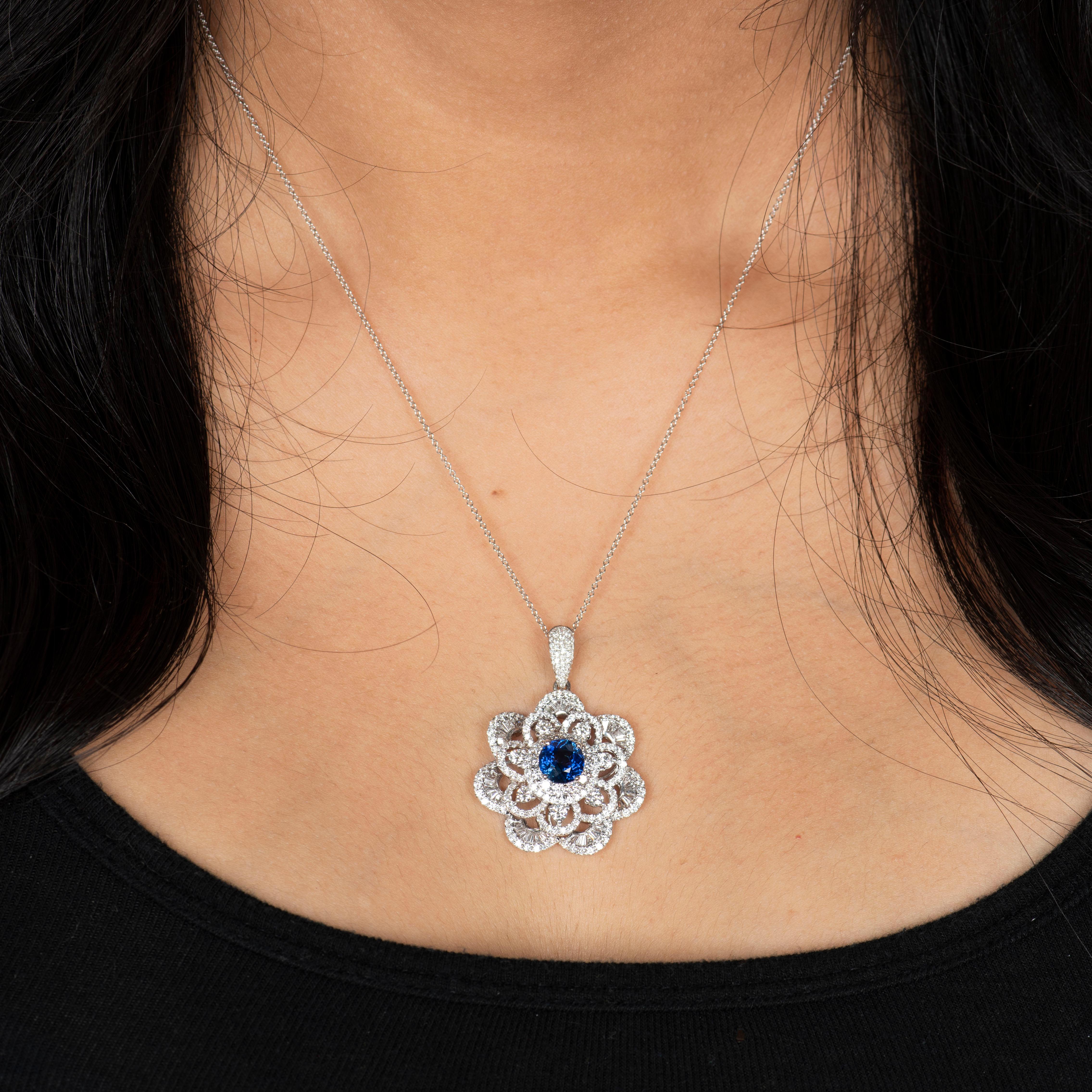 Gorgeous 18K white gold diamond flower pendant that features one 2.05 carat natural round rich blue sapphire. The sapphire is beautifully surrounded by 3.90 carats of fine round brilliant and tapered baguette diamonds. 

Diamond quality: G-H color,