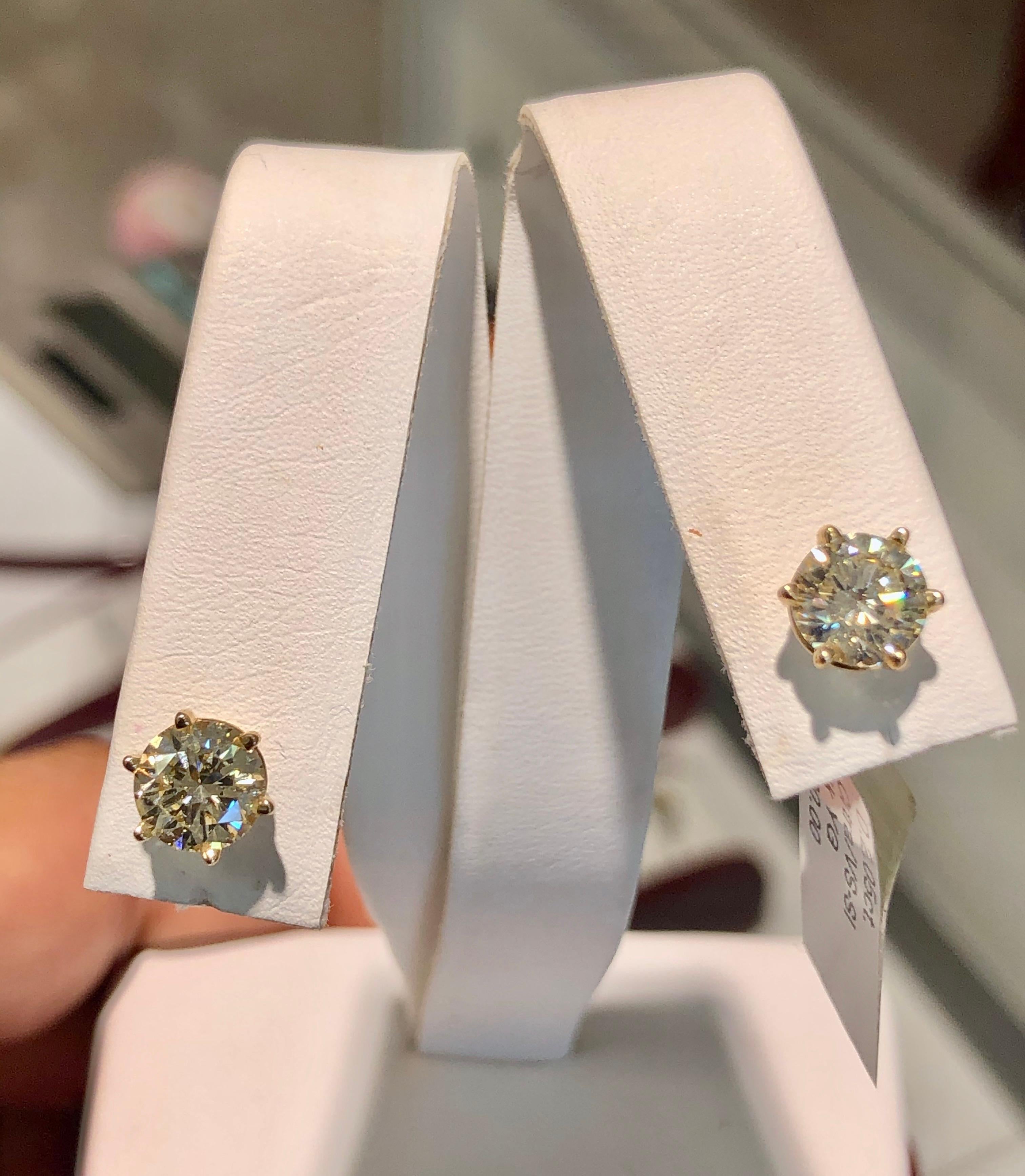 These diamond stud earrings feature two matching perfectly natural diamonds total weight 2.05 carat, color M, clarity VS2-SI1 round brilliant cut. Each stone is six-claw-set in an open-back setting 14 yellow gold.
New Condition
