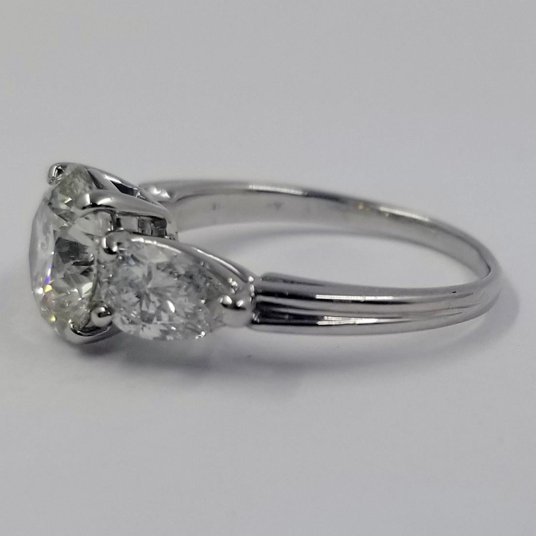 Platinum Engagement Ring Featuring A 2.05 Carat Round Brilliant Diamond Centerstone. The Diamond is GIA Graded as I1 Clarity & L Color, Report Number 6204888775. The Ring Also Contains 2 Pear Shaped Diamonds Totaling Approximately 1 Carat with SI1