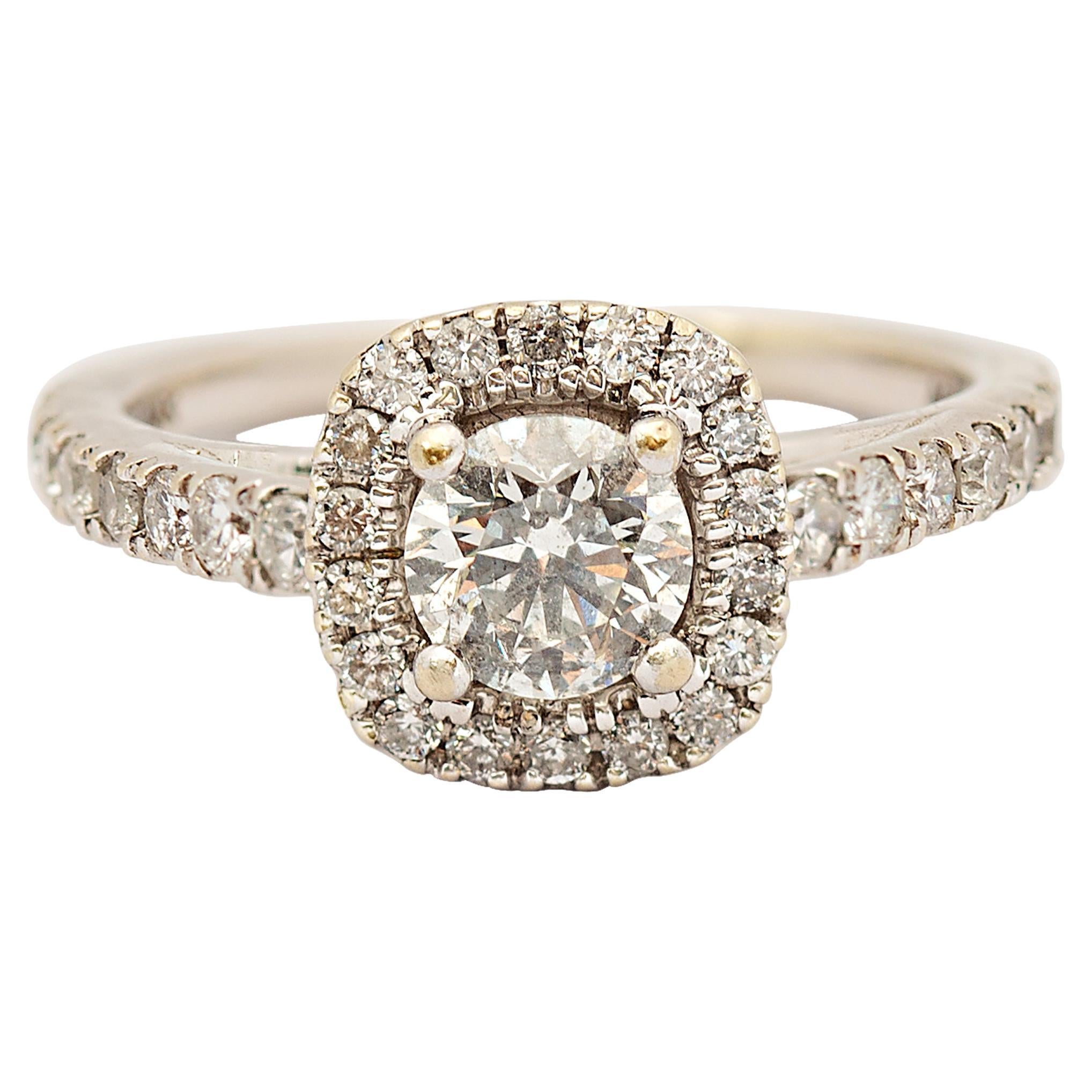 Beautiful set of diamond engagement ring and wedding band. The diamond engagement ring features a round brilliant cut diamond weighing approximately 0.65 carat.  Surrounding this diamond is a cushion-shaped halo of near colorless round brilliant cut