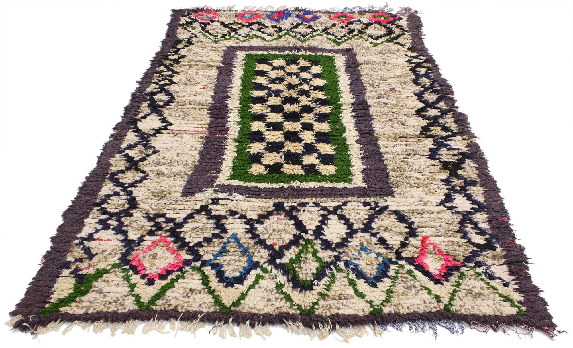 20569 vintage Berber Moroccan Boucherouite rug. The subtlety of a cream colored background allows the stark colors used to ornament the Berber Moroccan rug to stand out. A myriad of different geometric shapes and themes decorate the foreground of
