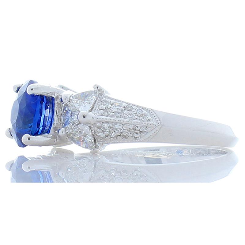 This ring is a pleasure to observe with a huge splash of vibrant color. It features a richly saturated 2.06 carat round sapphire. The gorgeous blue tone, high clarity, and intense transparency is simply stunning and contrasts wonderfully with the