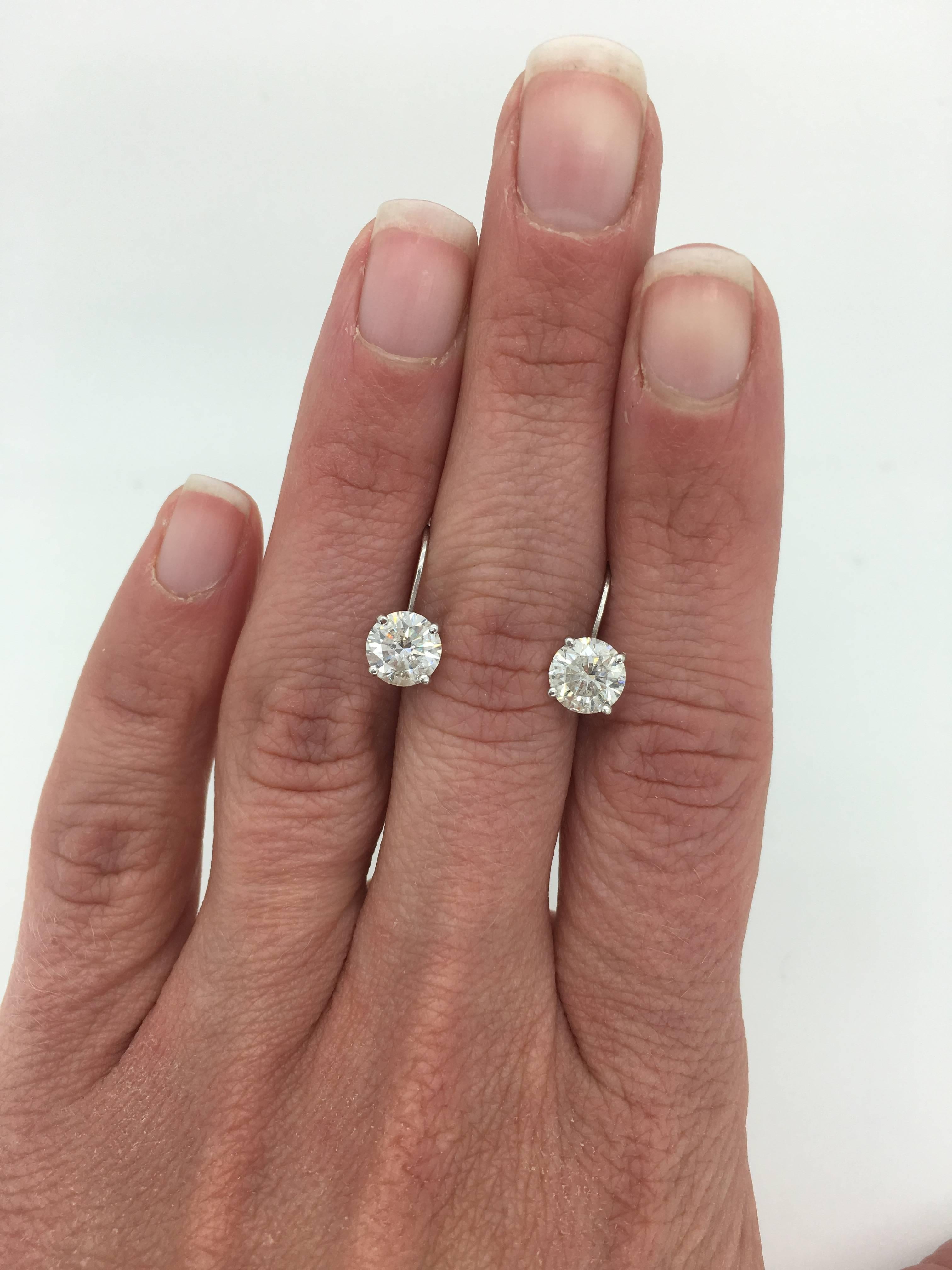 2.06ct Round Brilliant cut diamonds mounted into 14k white gold lever back earrings. 

One Round Brilliant cut diamond weighing approximately .98ct
One Round Brilliant cut diamond weighting approximately 1.08ct 
Total diamond weight of 2.06ctw