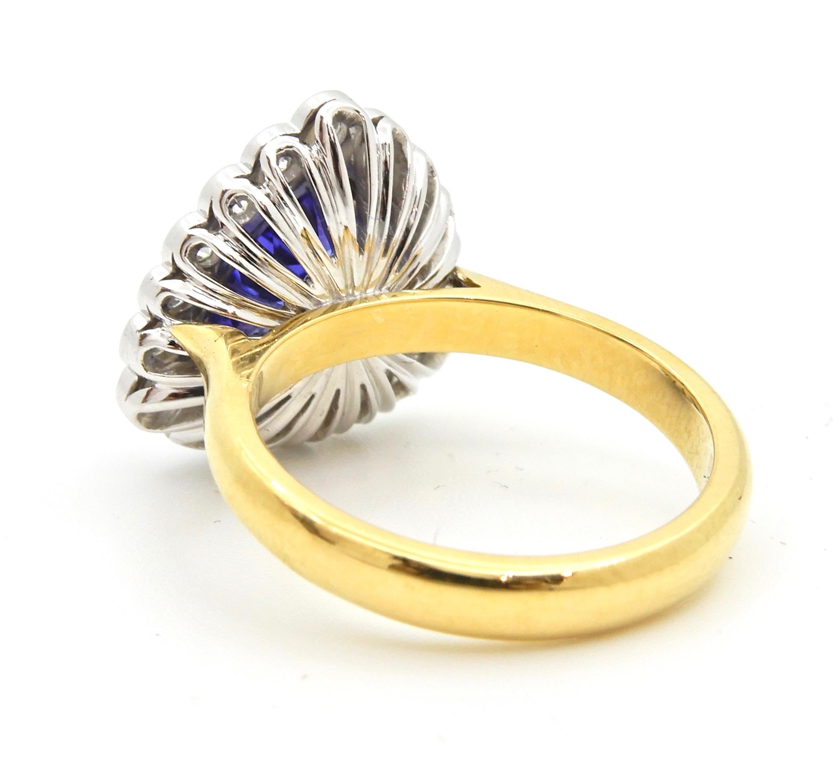 This 2.06 carat trilliant cut Tanzanite and Diamond ring is set in 18 carat gold. The slightly rounded, flat edge, yellow gold band rises to a white gold triangular cluster of one bezel set trilliant cut Tanzanite surrounded by a scalloped boarder