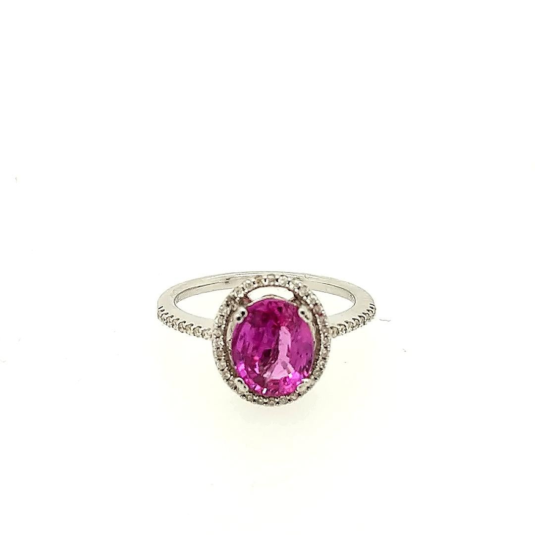 This pink sapphire cocktail ring is crafted in 14k white gold featuring (1) oval pink sapphire weighing 2.06 carat and (47) diamonds weighing approximately .25cttw. 