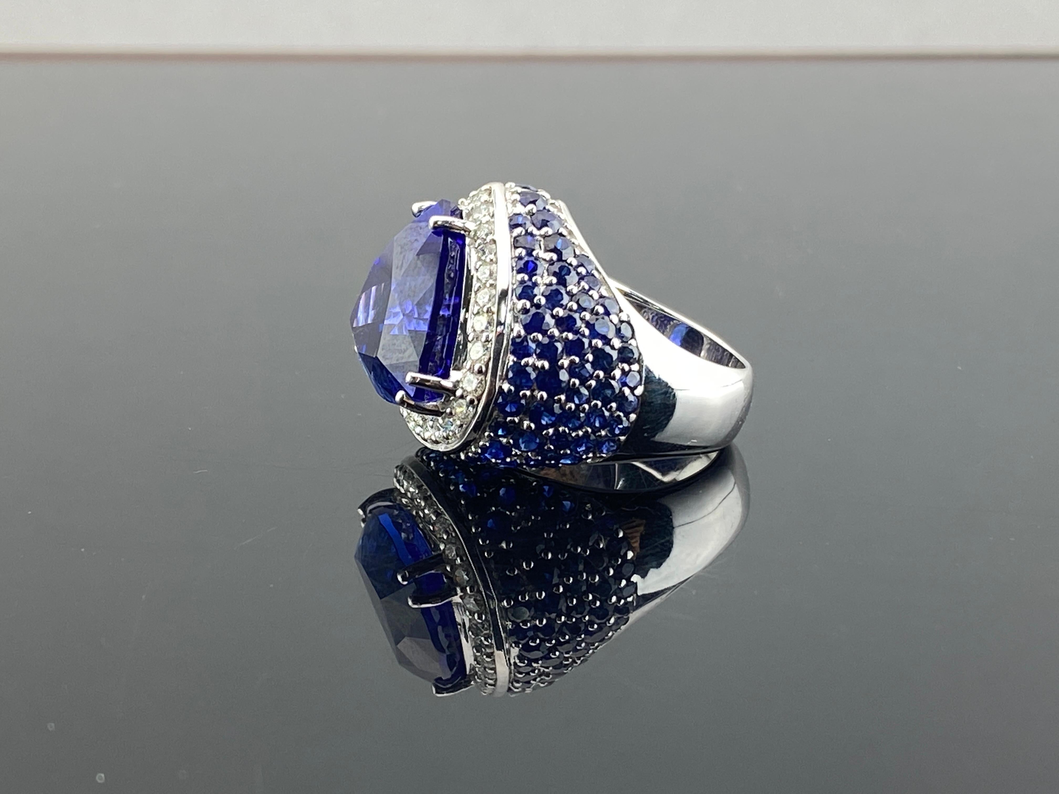 A beautiful statement ring, with a 20.6 carat vivid blue, transparent Tanzanite center stone - surrounded by 0.88 carats White Diamond and 4.95 carats Blue Sapphire all set in 18K White Gold.

We will be happy to answer any questions about this