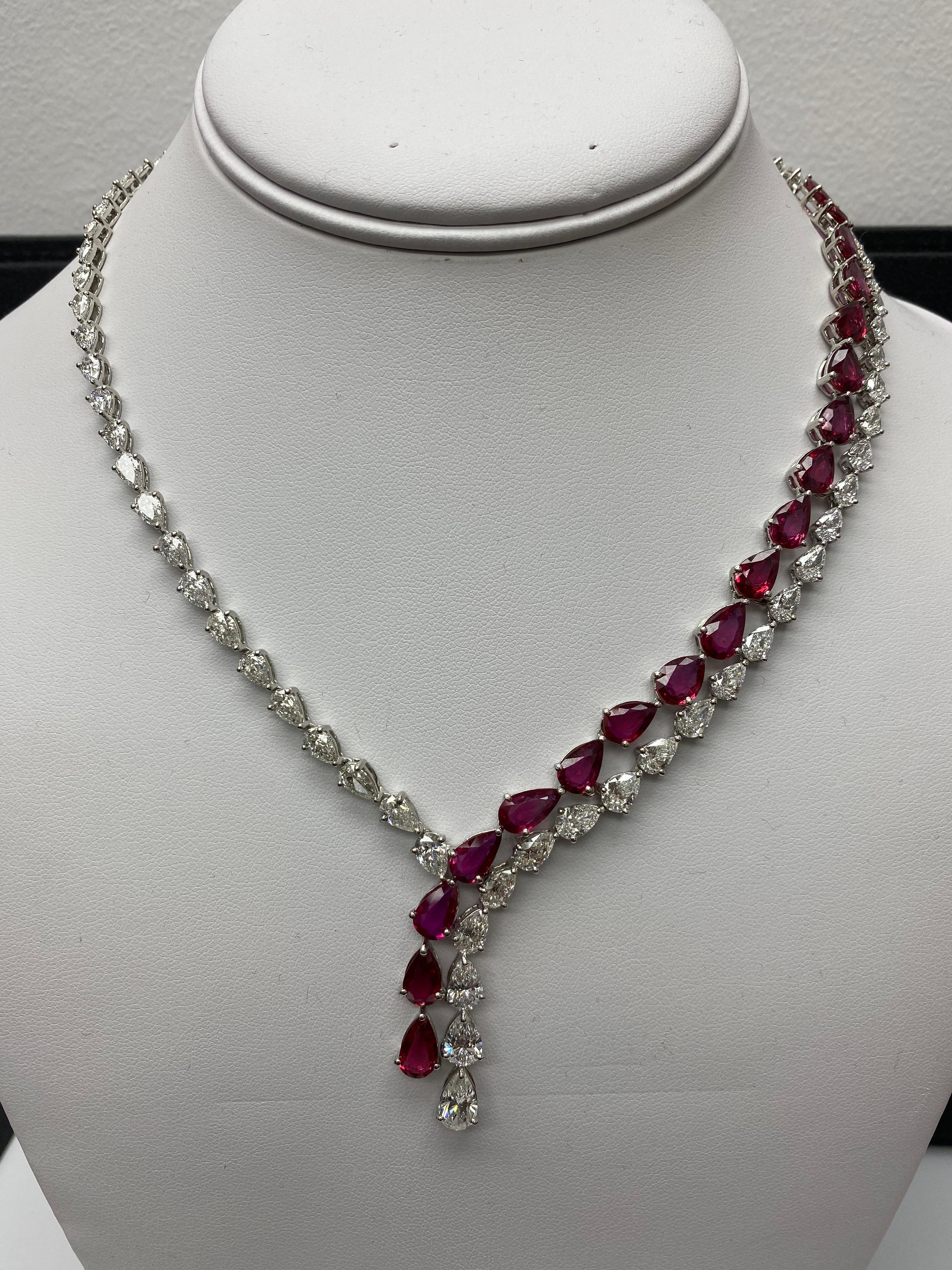 A unique and magnificent piece that showcases the two magnificent sides of diamonds with ruby on one side. On one side, features 19 natural unheated pear shape rubies weighing 20.62 carats. 79 pear shape diamonds on both sides weigh 20.04 carats in