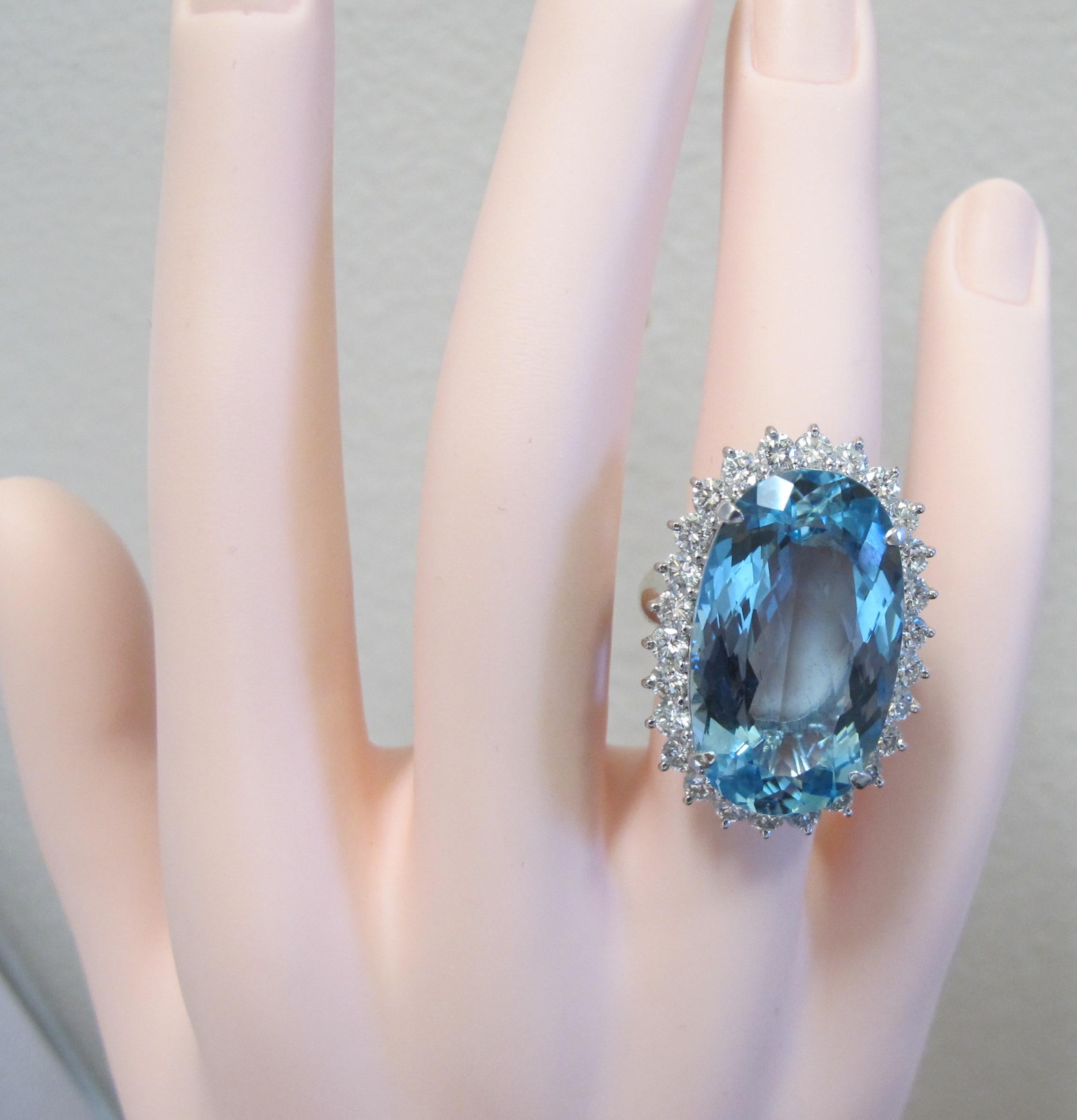 Set in a Platinum mounting is a 20.63 carat Oval shaped Aquamarine stone surrounded by 26 round brilliant cut diamonds with a total diamond weight of 2.20 carats.  Color is G-H, Clarity is VS.  Ring size is 5.