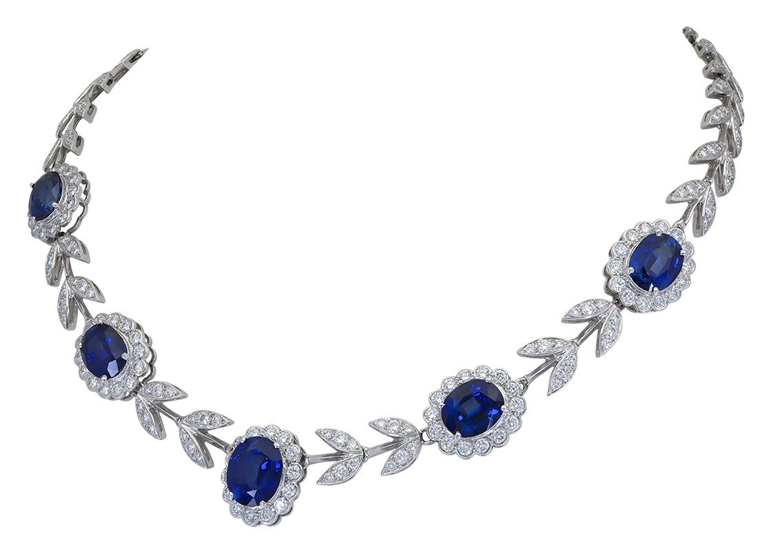 A stylish necklace showcasing five oval cut diamonds set in a flower design halo made of diamonds. Each sapphire halo is spaced by diamond leaves. Made in 18k white gold.
Sapphires weigh 20.65 carats total.
Diamonds weigh 8.50 carats total.
16.5