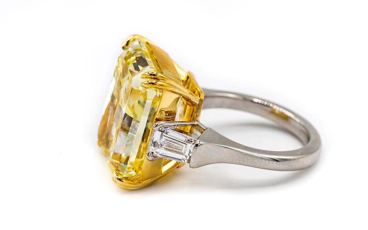 Striking 20.67-carat Fancy Intense Yellow / Internally Flawless three stone diamond, flanked by two bullet-cut high white diamonds 1.01cttw. 
Center Radiant Cut diamond is an impressive GIA-certified Flawless diamond without any imperfections or
