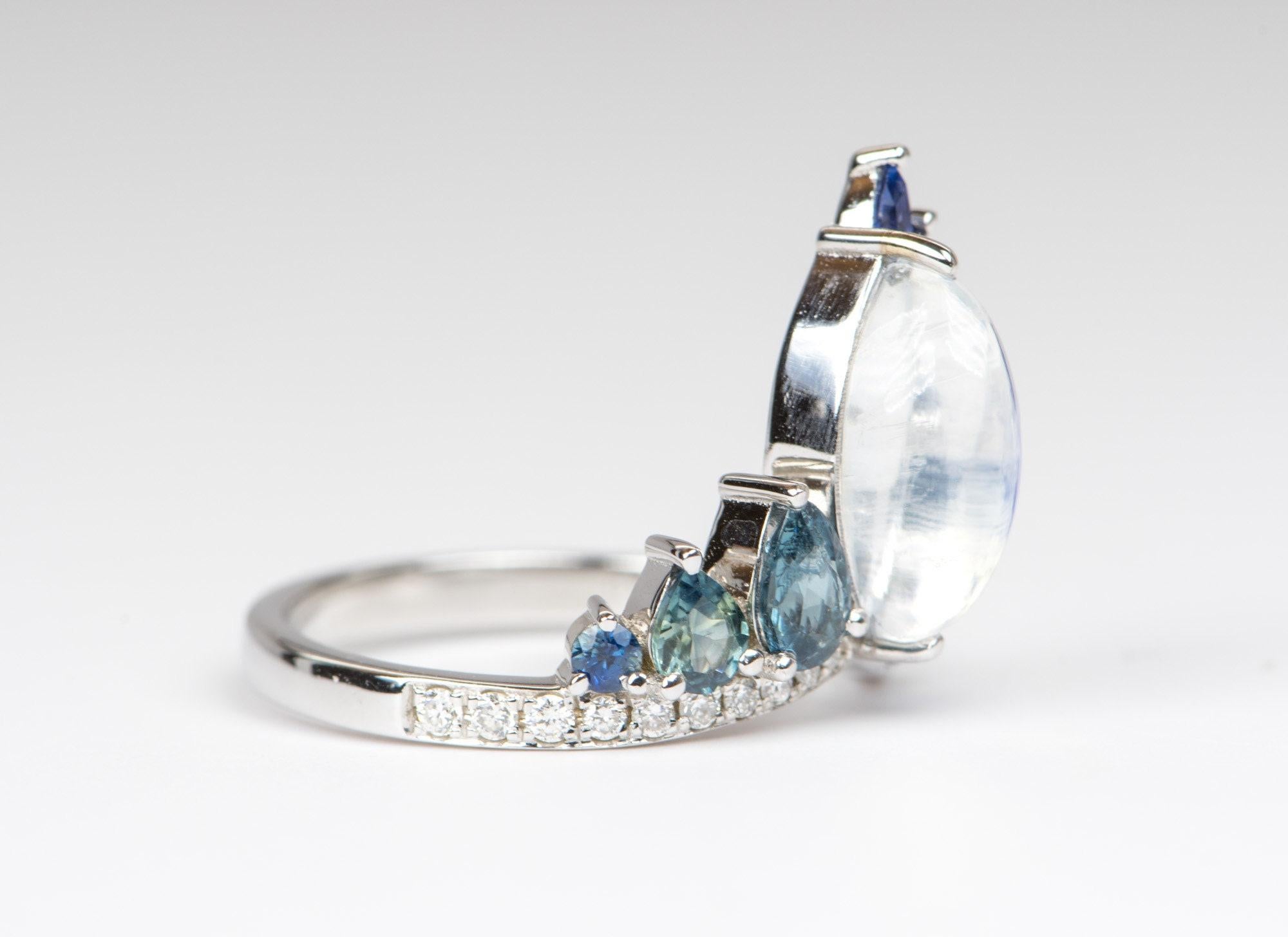 â™¥ Solid 14K white gold ring set with a marquise shaped rainbow moonstone in the center with teal sapphires on the side
â™¥ This blue flash peacock ring is a stunning statement ring!
â™¥ The overall setting measures 16.1mm in width, 17.1mm in