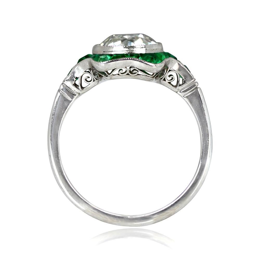 This ring has a 2.06-carat old European cut diamond with J color and VS1 clarity, surrounded by natural emeralds. The emerald halo extends to the shoulders and has an open-work under-gallery. The total emerald weight is approximately 0.75