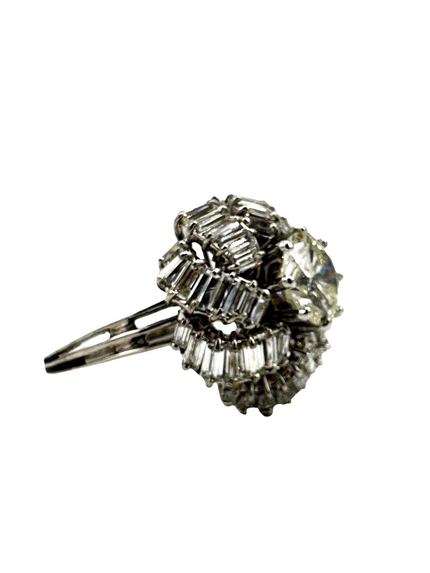 Dieser wunderschöne, einzigartige Ring besteht aus einem runden Brillanten von 2,07 Karat, umgeben von einem gewölbten Wirbel aus Baguette-Diamanten mit einem Gesamtgewicht von 1,92 Karat, gefasst in 18 Karat Weißgold.  Der Diamant in der Mitte ist