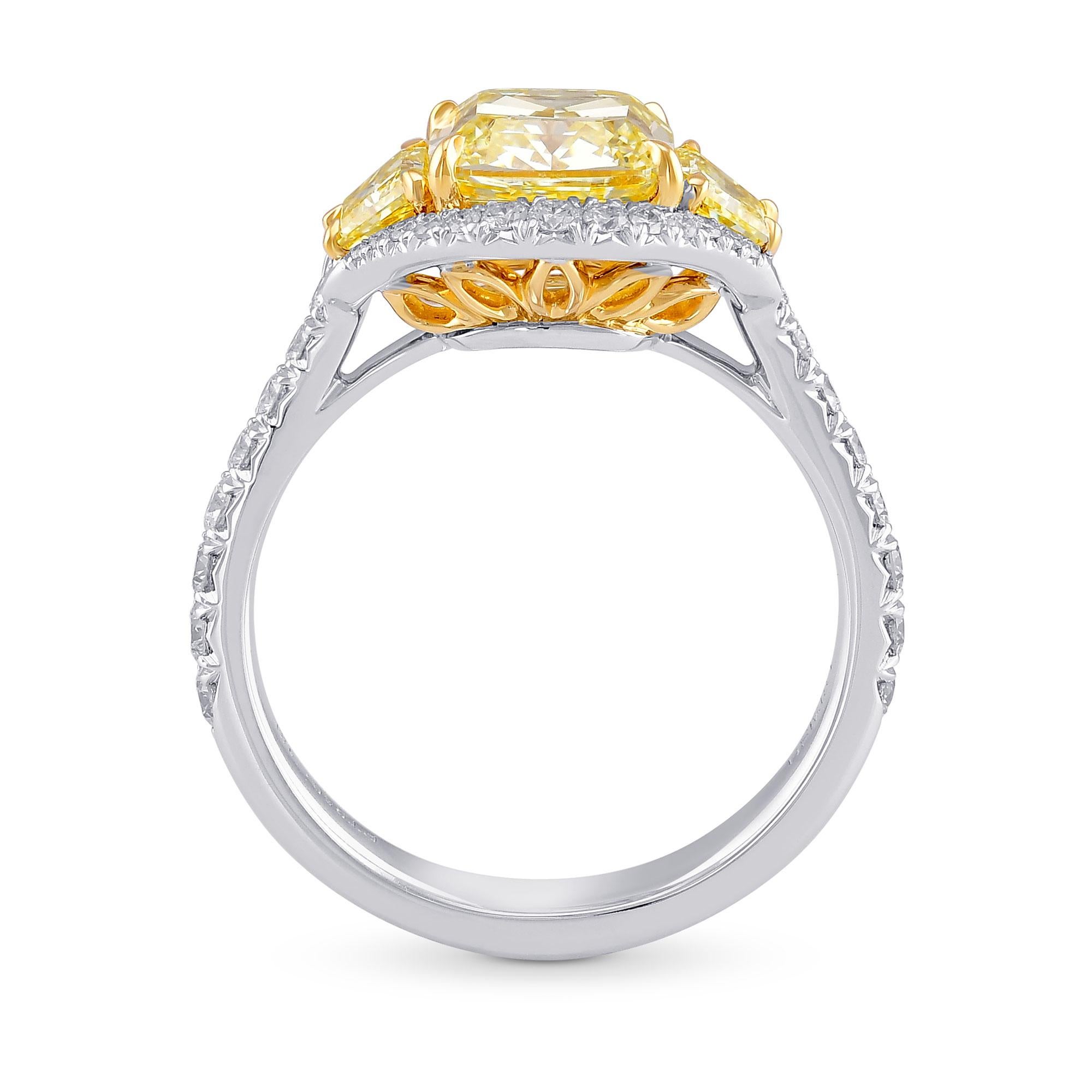 Magnifique bague de halo à trois pierres, avec un diamant central pesant 2,07 ct et certifié par le GIA. Le diamant est flanqué de diamants trapézoïdaux de couleur jaune fantaisie et rehaussé d'un halo en pavé français, avec des pierres latérales