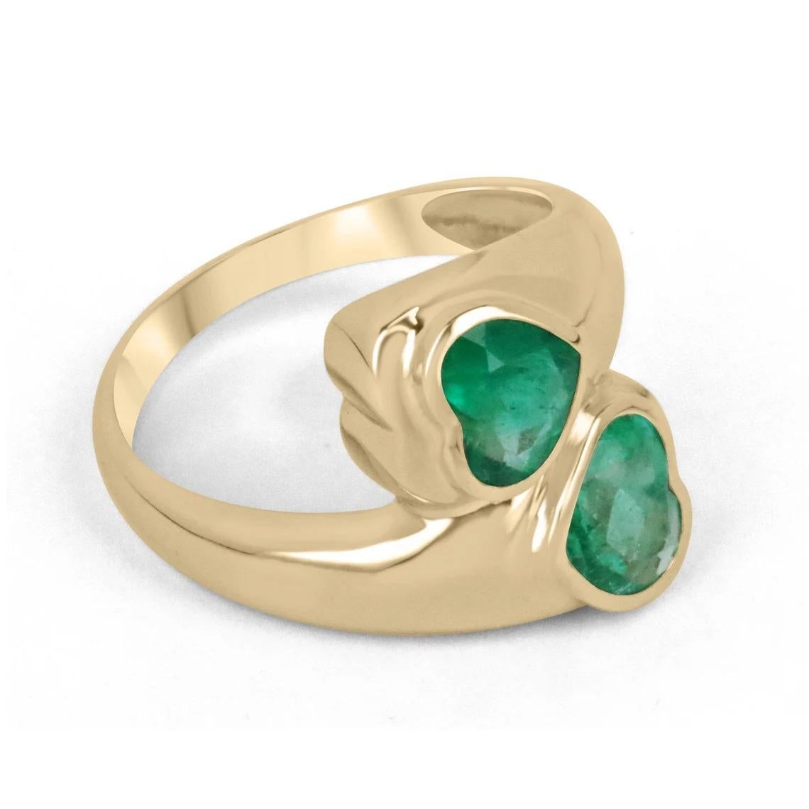 A fascinating, emerald dual bypass statement ring. This beauty features a total of 2.07-carats, of natural Colombian heart-cut emeralds with remarkable characteristics. Both gemstones display an enthralling vivid green color, transparent clarity,