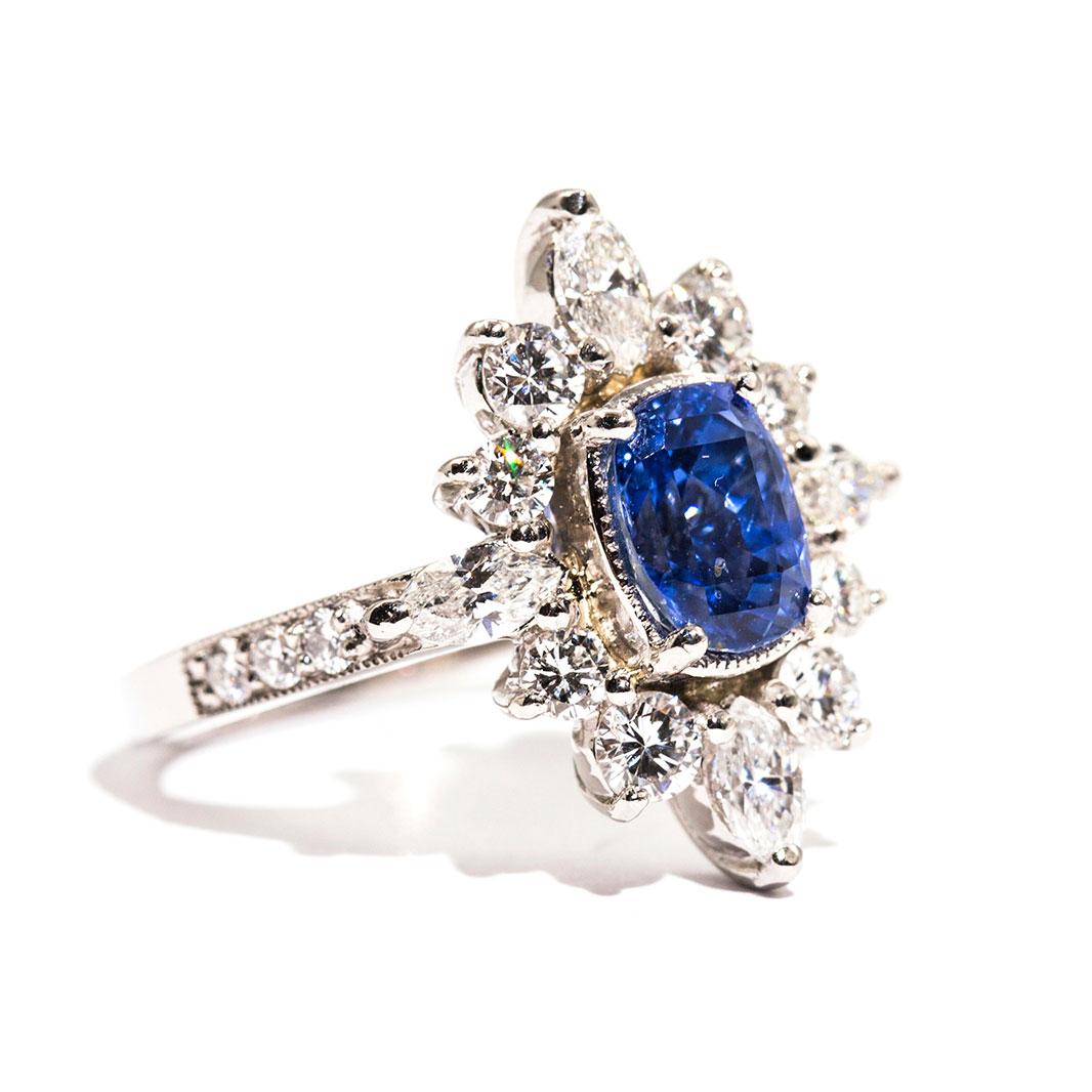 Forged in platinum is this captivating ring that features a breathtaking 2.08 carat cushion cut natural sapphire of a bright cornflower type blue colour and is encompassed with total of 1.43 carats of bright sparkling white round brilliant cut and