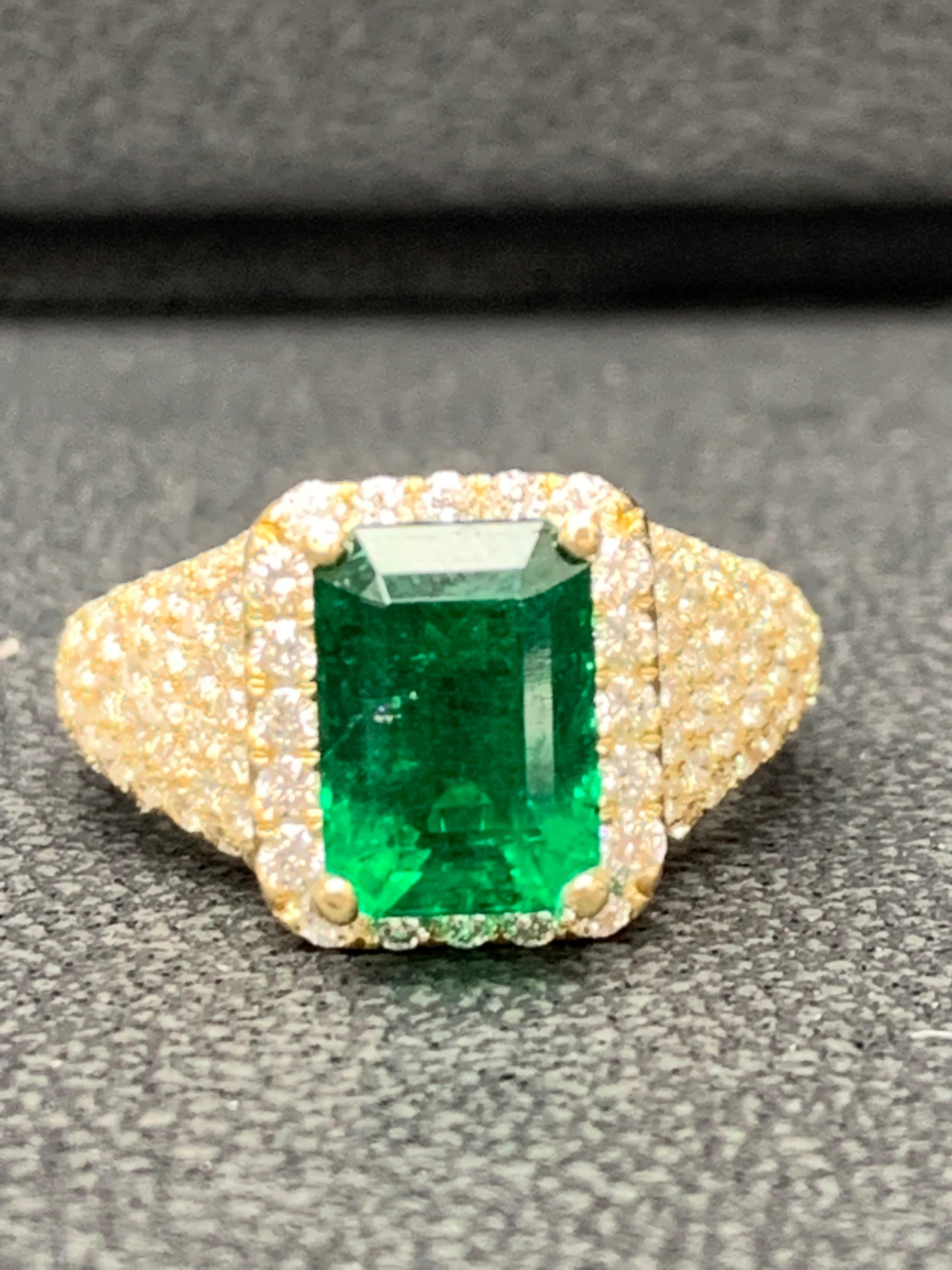 A uniquely-designed ring showcasing a 2.08 carat Emerald Cut Emerald. Surrounding the center stone are brilliant-cut round diamonds in an 18 karat yellow gold mounting. 146 diamonds weigh 2.01 carat in total.