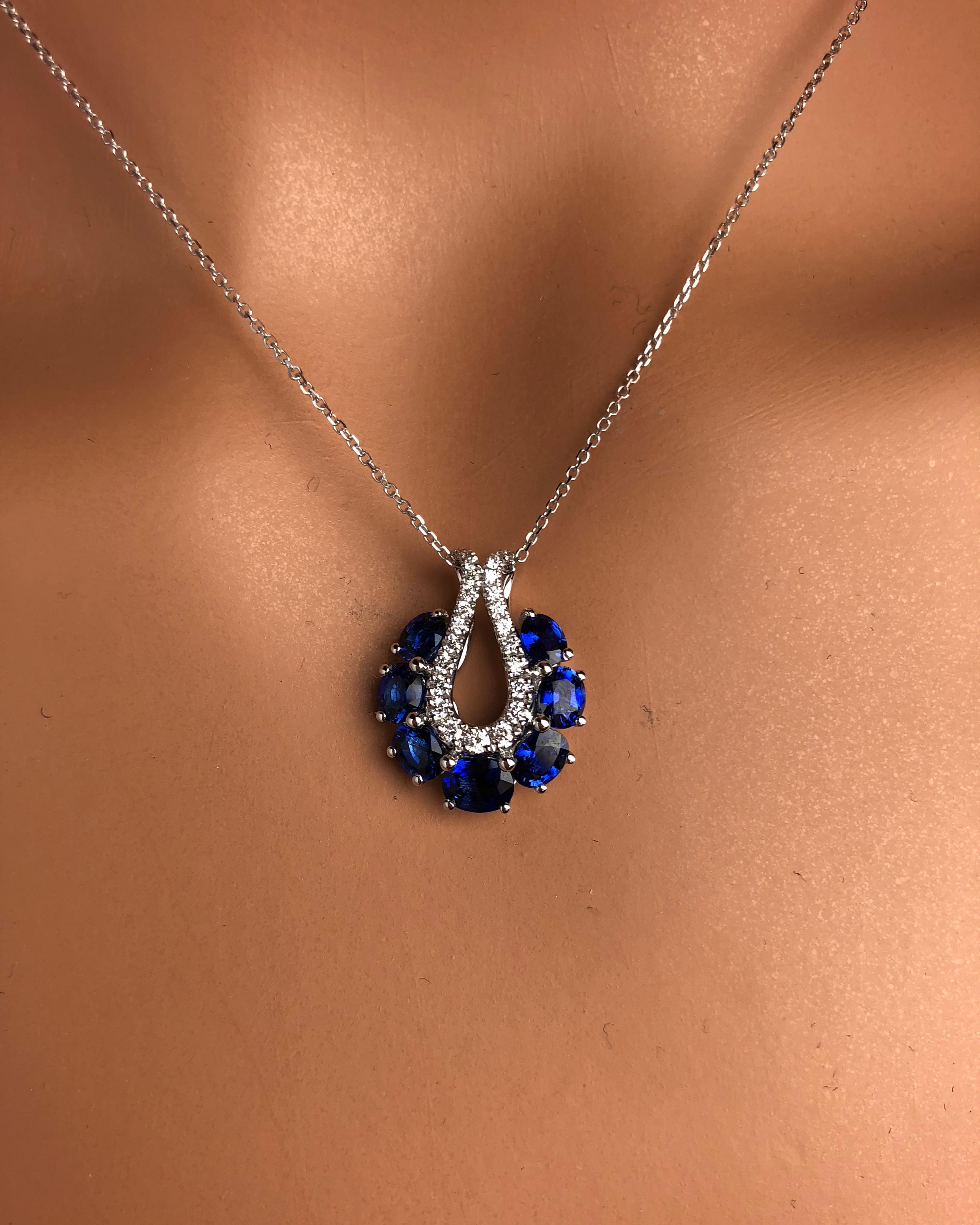 This lovely halo pendant features seven oval cut blue Sapphires, total 2.01 carats, encircling an open teardrop setting of round white diamonds.

Center: 2.08 carats blue sapphire
Diamond Halo: 25 round diamonds total 0.25 carats
Set in 18k White