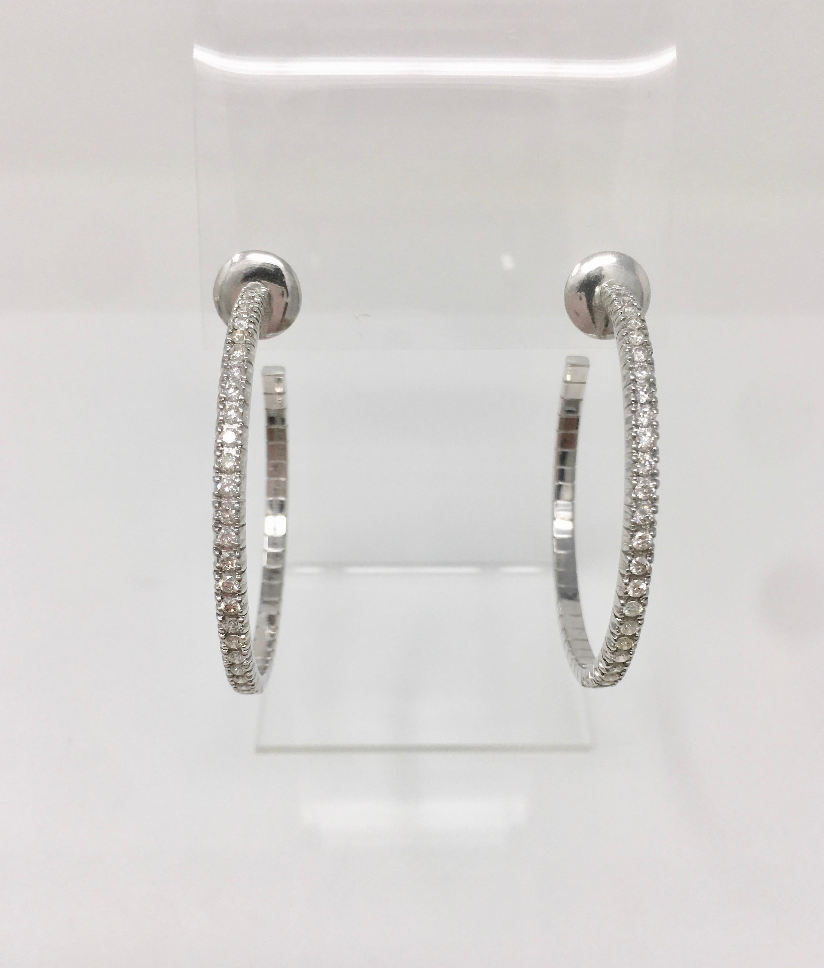 A dramatic 1 3/4 inches in diameter covered with white round brilliant diamond weighing 2.08 carat approximately with HI color and SI clarity make these beautiful hoops a show stopper. They are hand made in 18 k white gold.